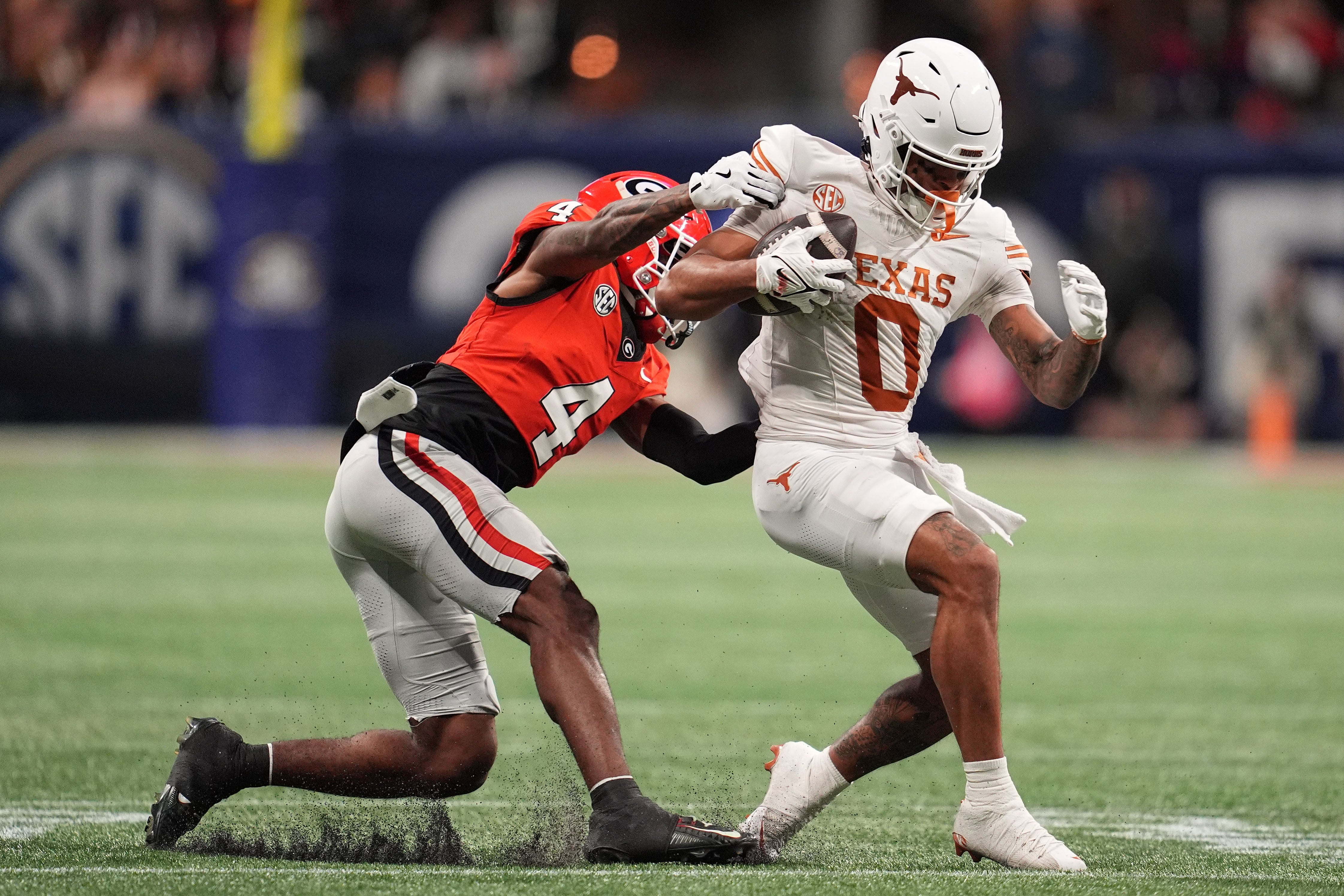 Georgia Bulldogs defensive back KJ Bolden (4) makes a tackle on Texas Longhorns wide receiver DeAndre Moore Jr. (0) during the first half in the 2024 SEC Championship game at Mercedes-Benz Stadium.