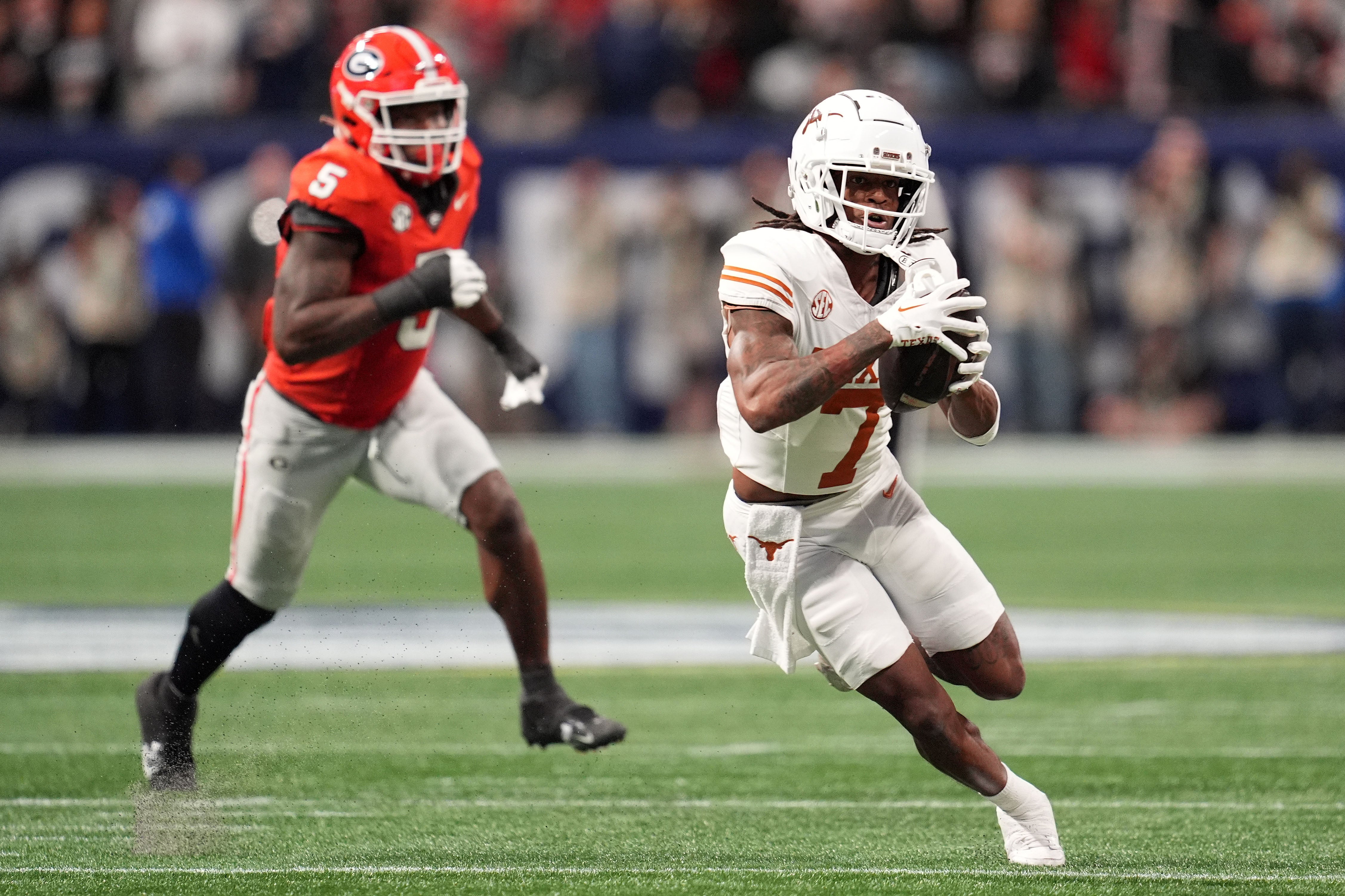 Dec 7, 2024; Atlanta, GA, USA; Texas Longhorns wide receiver Isaiah Bond (7) makes a catch past Georgia Bulldogs linebacker Raylen Wilson (5) during the first half in the 2024 SEC Championship game at Mercedes-Benz Stadium.