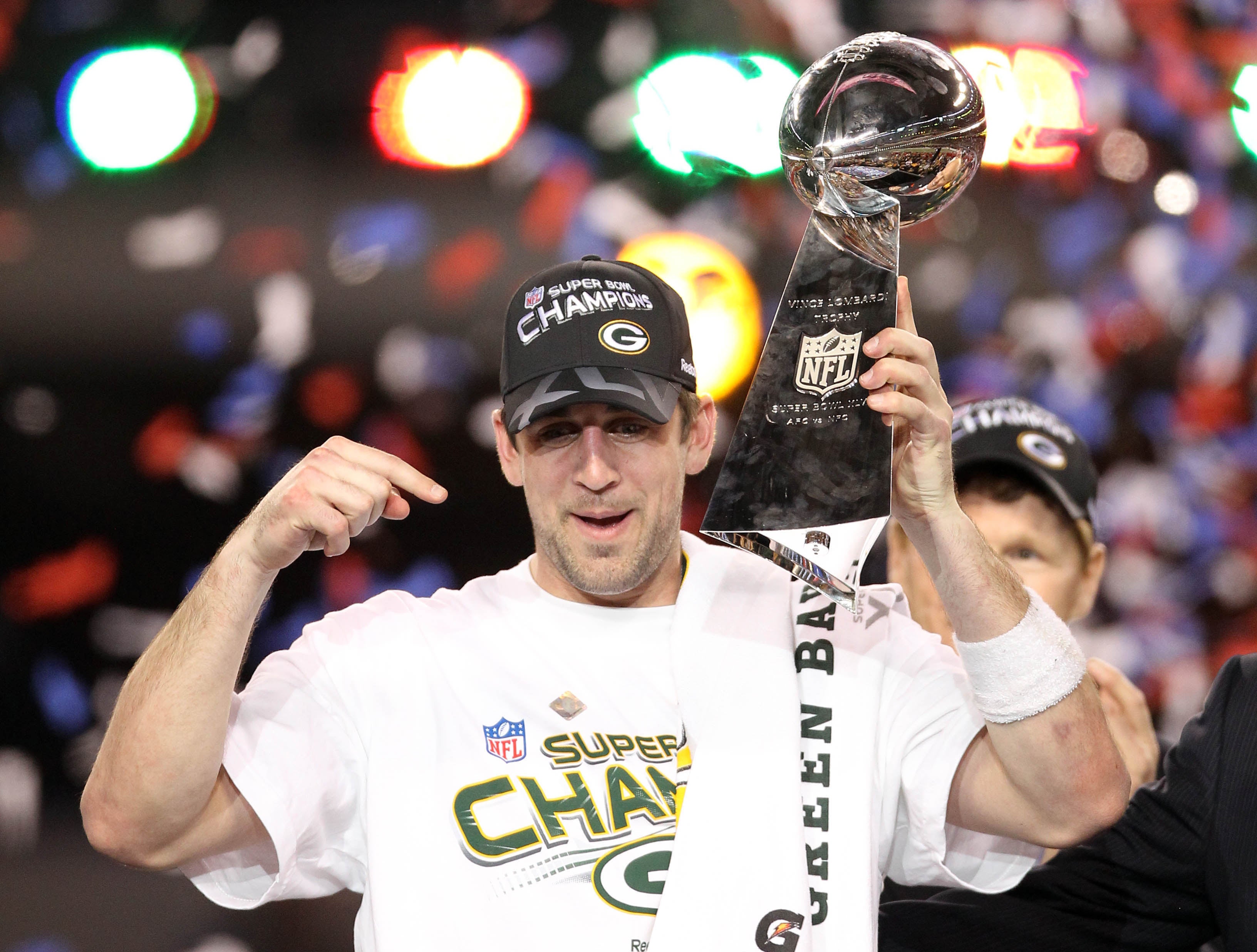 Green Bay Packers quarterback Aaron Rodgers hoists the Vince Lombardi Trophy after defeating the Pittsburgh Steelers in Super Bowl XLV at Cowboys Stadium. 