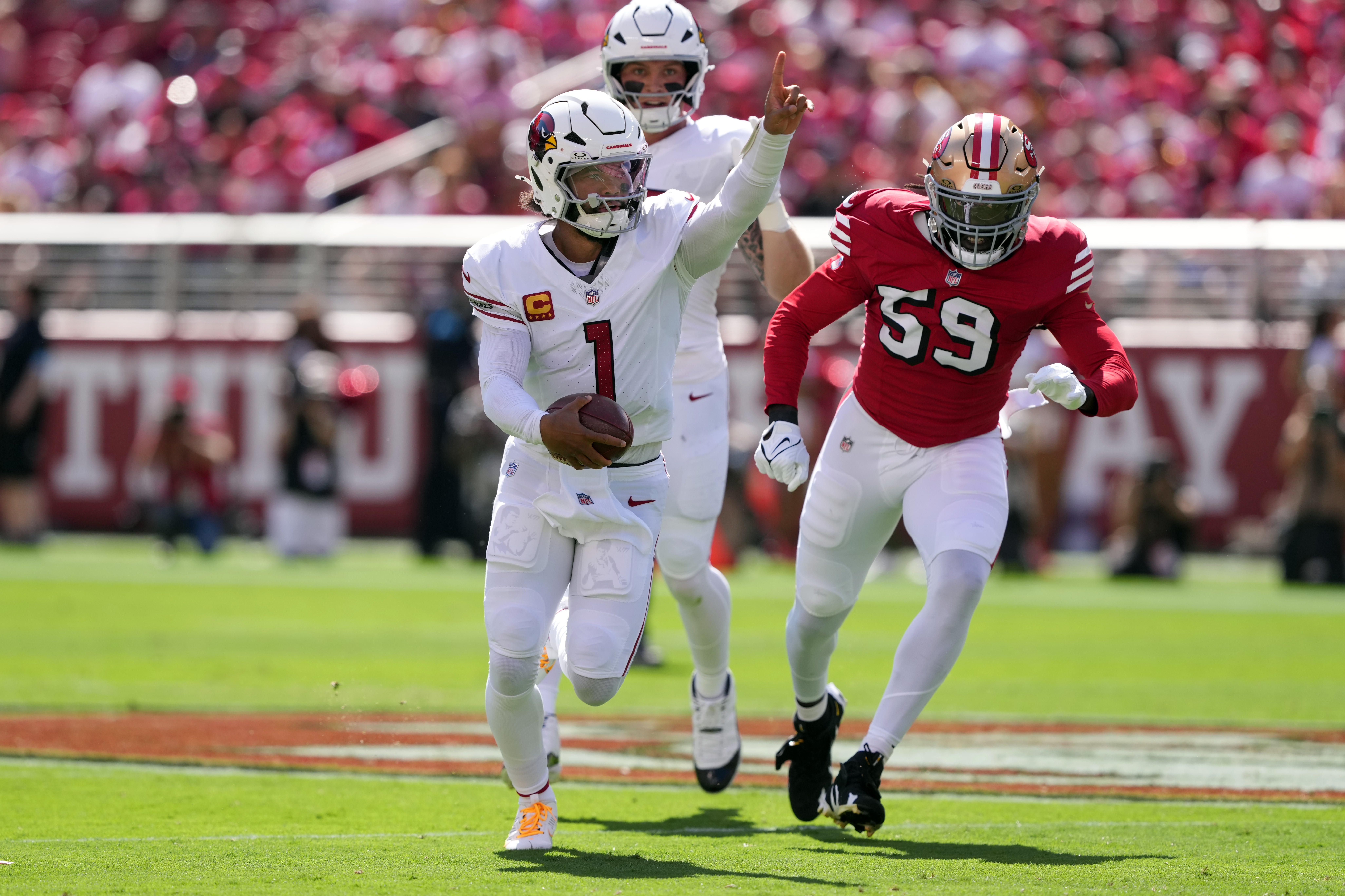 Arizona Cardinals quarterback Kyler Murray (1) gestures while rushing for a touchdown against the San Francisco 49ers