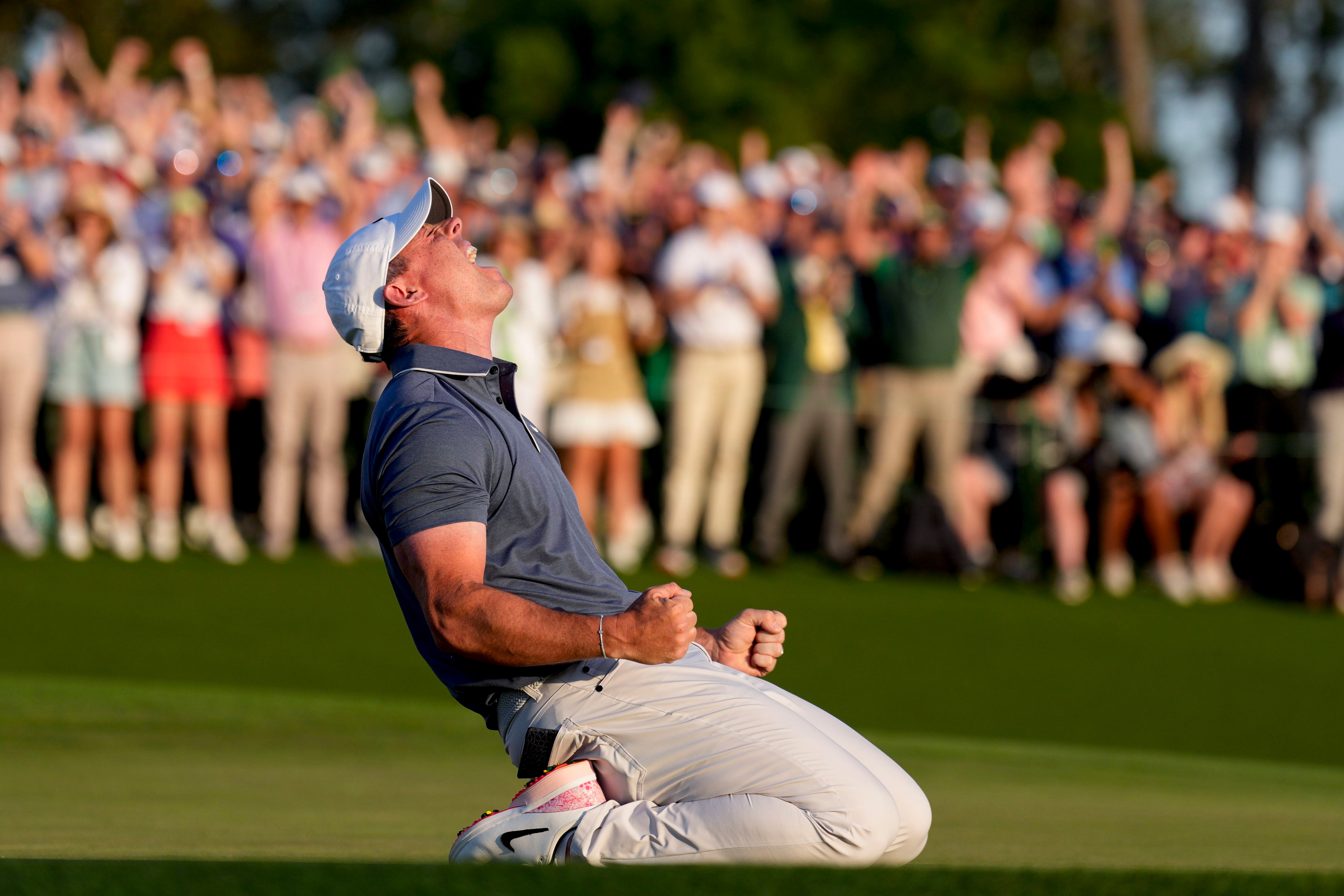 Rory McIlroy falls to his knees in celebration after winning a playoff on the no. 18 green during the final round of the Masters Tournament at Augusta National Golf Club.