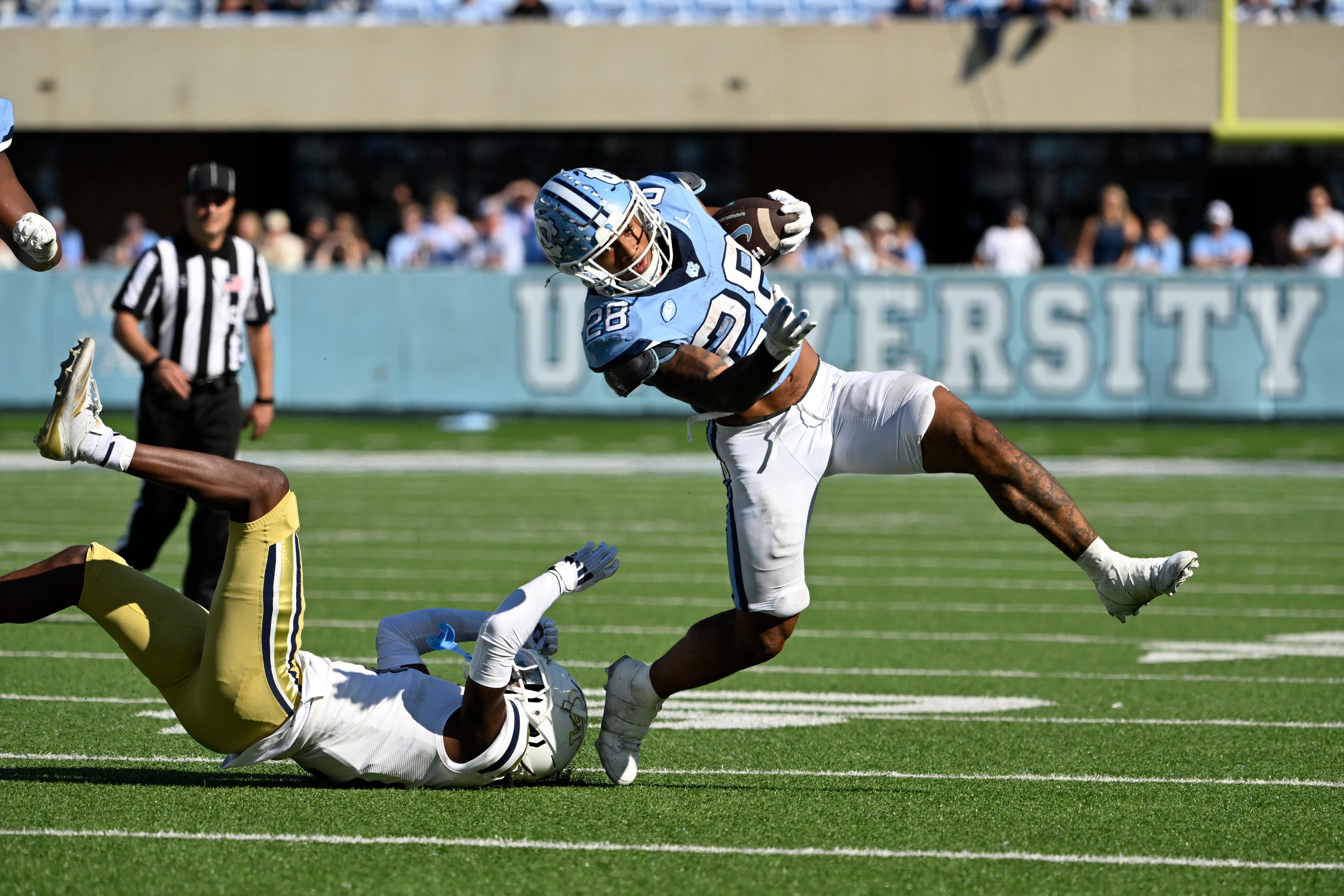 North Carolina Tar Heels running back Omarion Hampton (28) with the ball as Georgia Tech Yellow Jackets defensive back Warren Burrell (4) defends in the fourth quarter at Kenan Memorial Stadium.