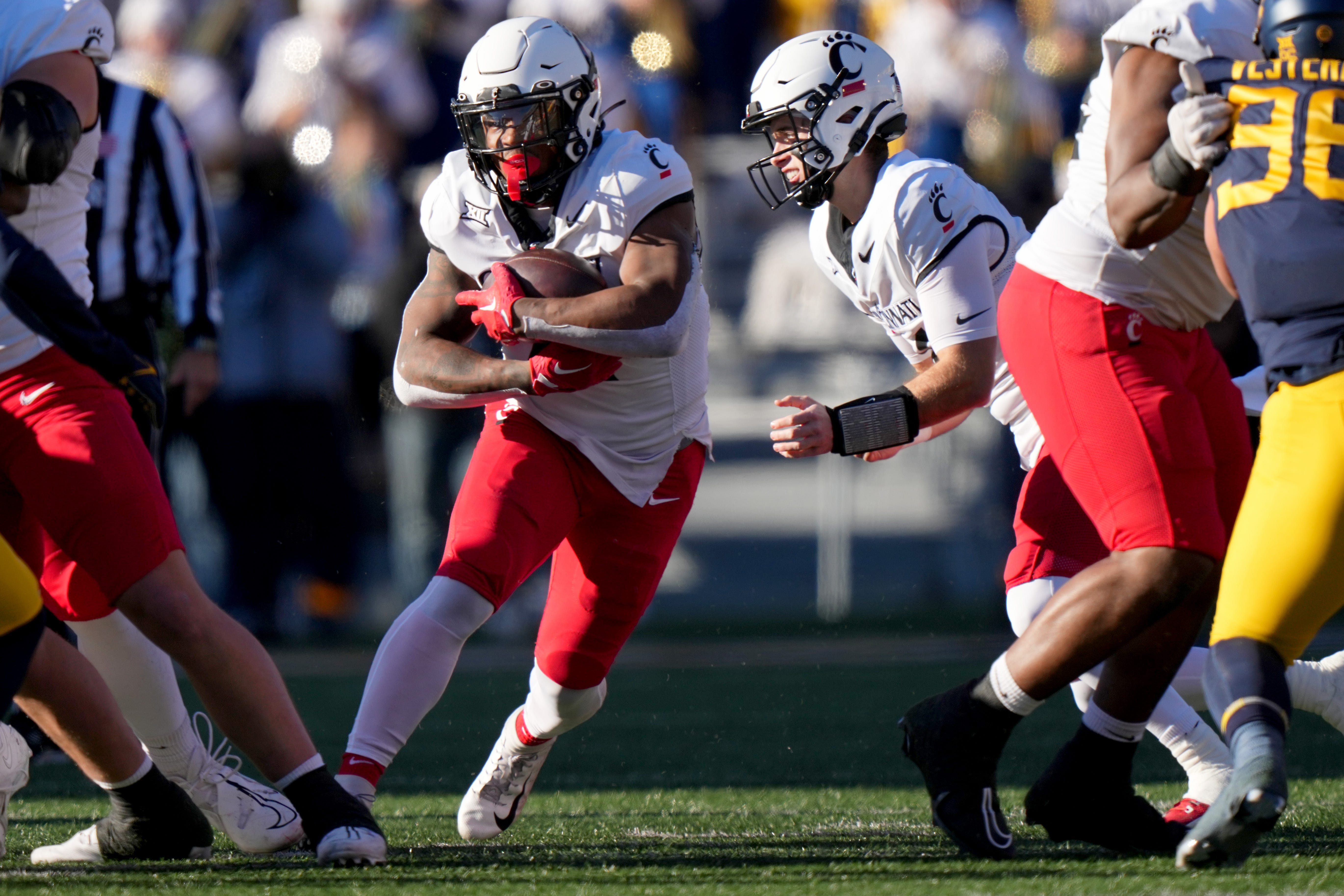 Cincinnati Bearcats running back Corey Kiner (21) carries the ball in the first quarter during an NCAA college football game between the Cincinnati Bearcats and the West Virginia Mountaineers, Saturday, Nov. 18, 2023, at Milan Puskar Stadium in Morgantown, W. Va.