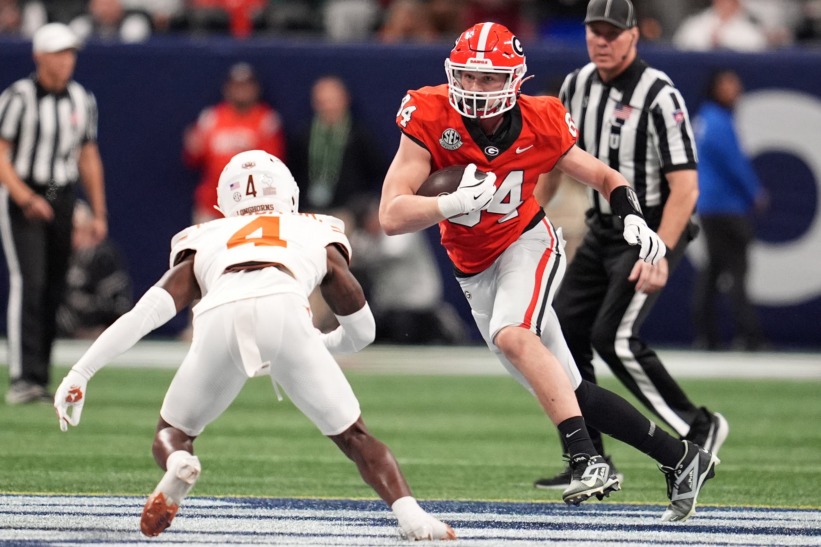 Georgia Bulldogs tight end Ben Yurosek (84) makes a catch against Texas Longhorns defensive back Andrew Mukuba (4) during the first half in the 2024 SEC Championship game at Mercedes-Benz Stadium.