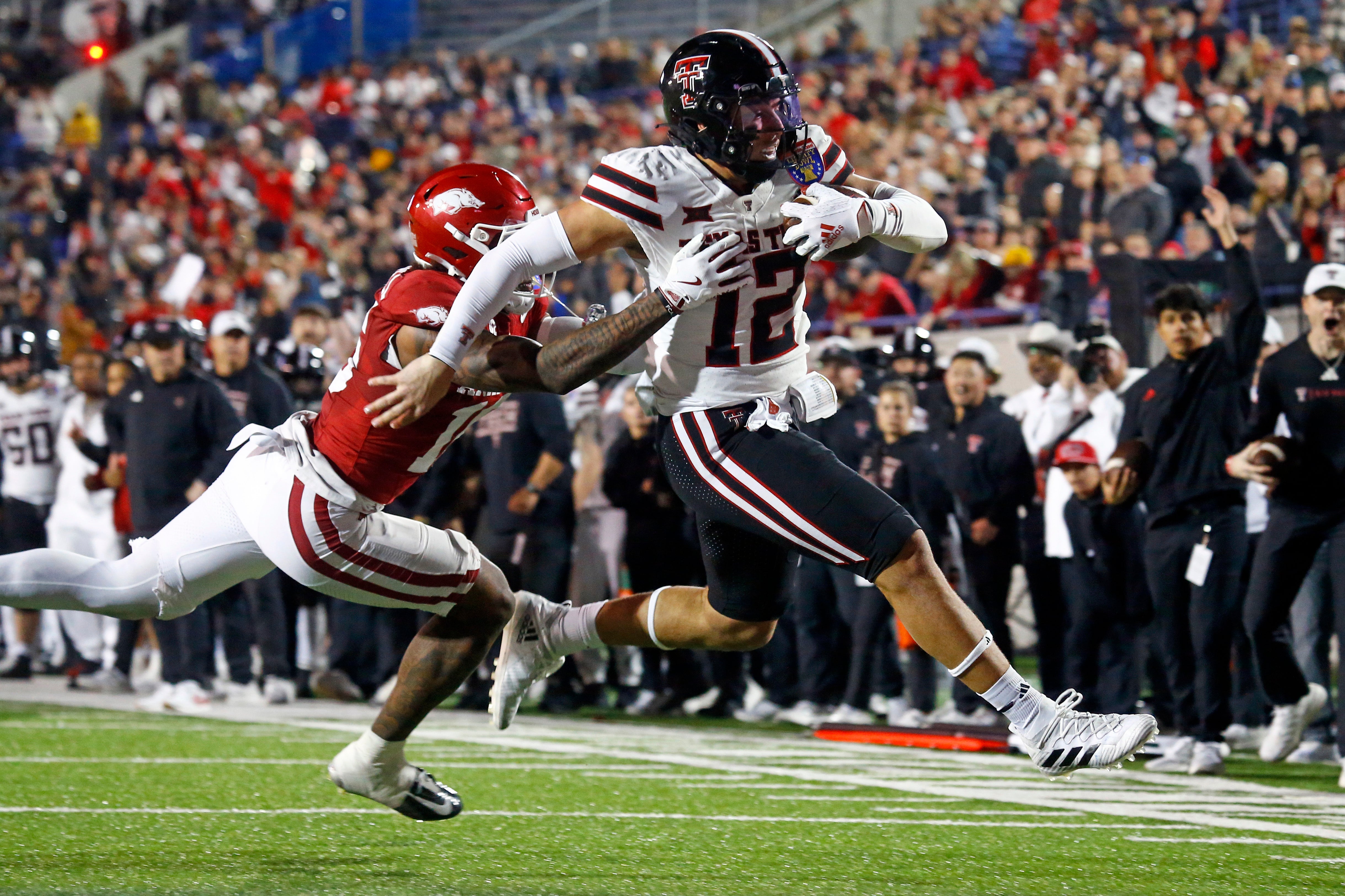 Dec 27, 2024; Memphis, TN, USA; Texas Tech Red Raiders tight end Jalin Conyers (12) runs the ball for a touchdown as Arkansas Razorbacks linebacker Xavian Sorey Jr. (10) attempts to make the tackle during the second quarter at Simmons Bank Liberty Stadium.