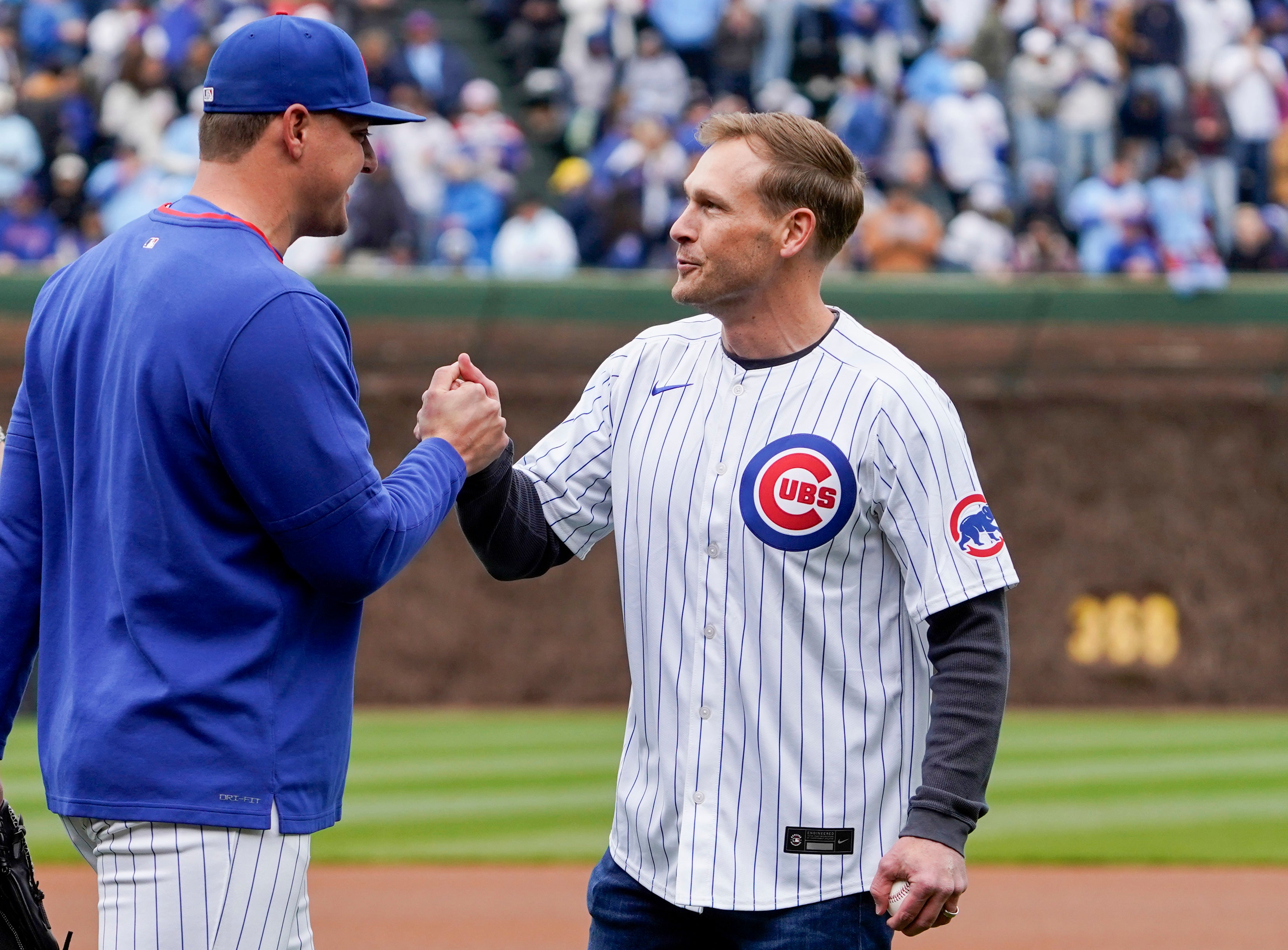 Apr 19, 2025; Chicago, Illinois, USA; Chicago Bears head coach Ben Johnson after throwing out a ceremonial first pitch shakes hands with Chicago Cubs pitcher Brad Keller (40) before the game against the Arizona Diamondbacks at Wrigley Field.
