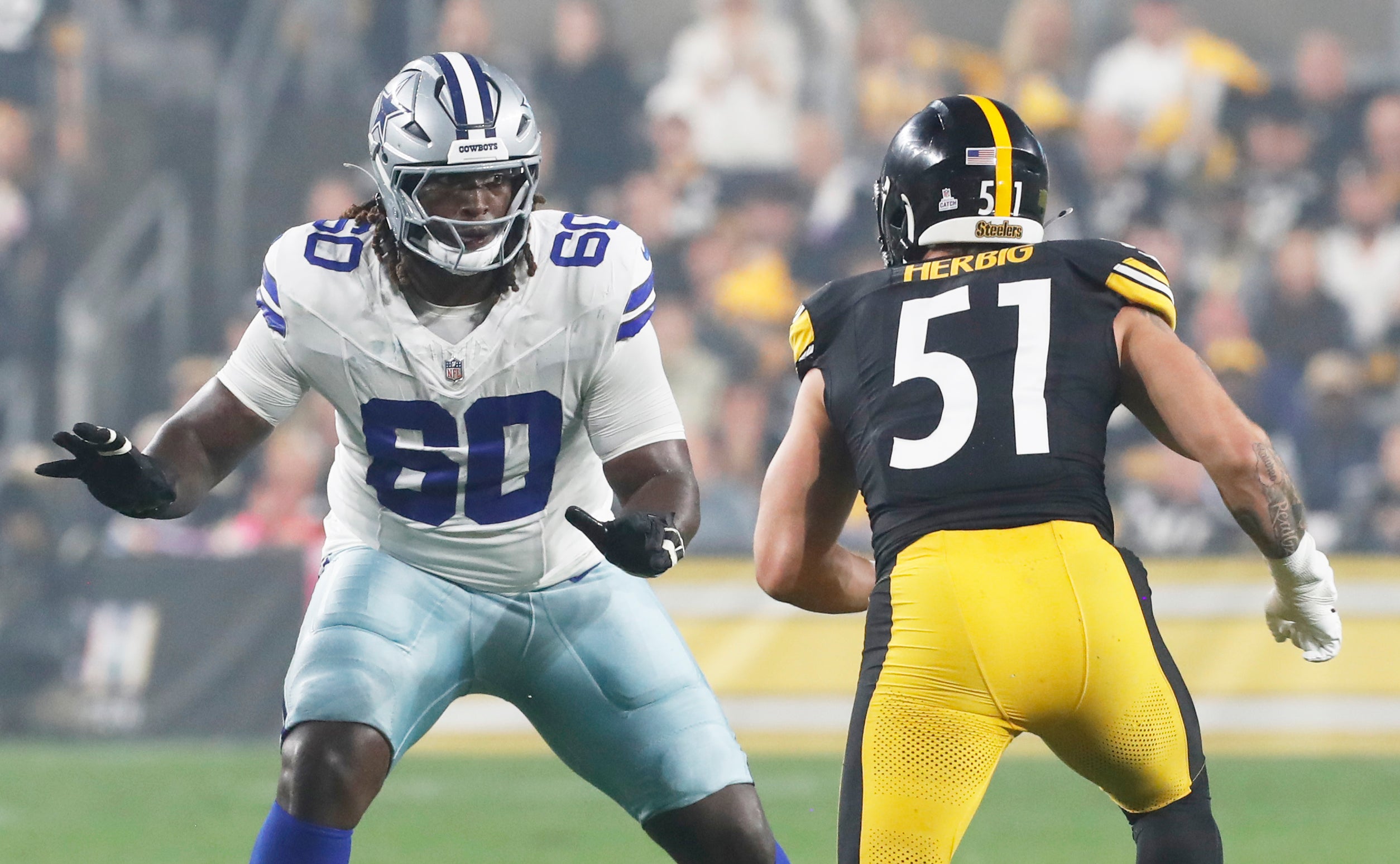 Dallas Cowboys offensive tackle Tyler Guyton (60) blocks at the line of scrimmage against Pittsburgh Steelers linebacker Nick Herbig (51) during the first quarter at Acrisure Stadium.