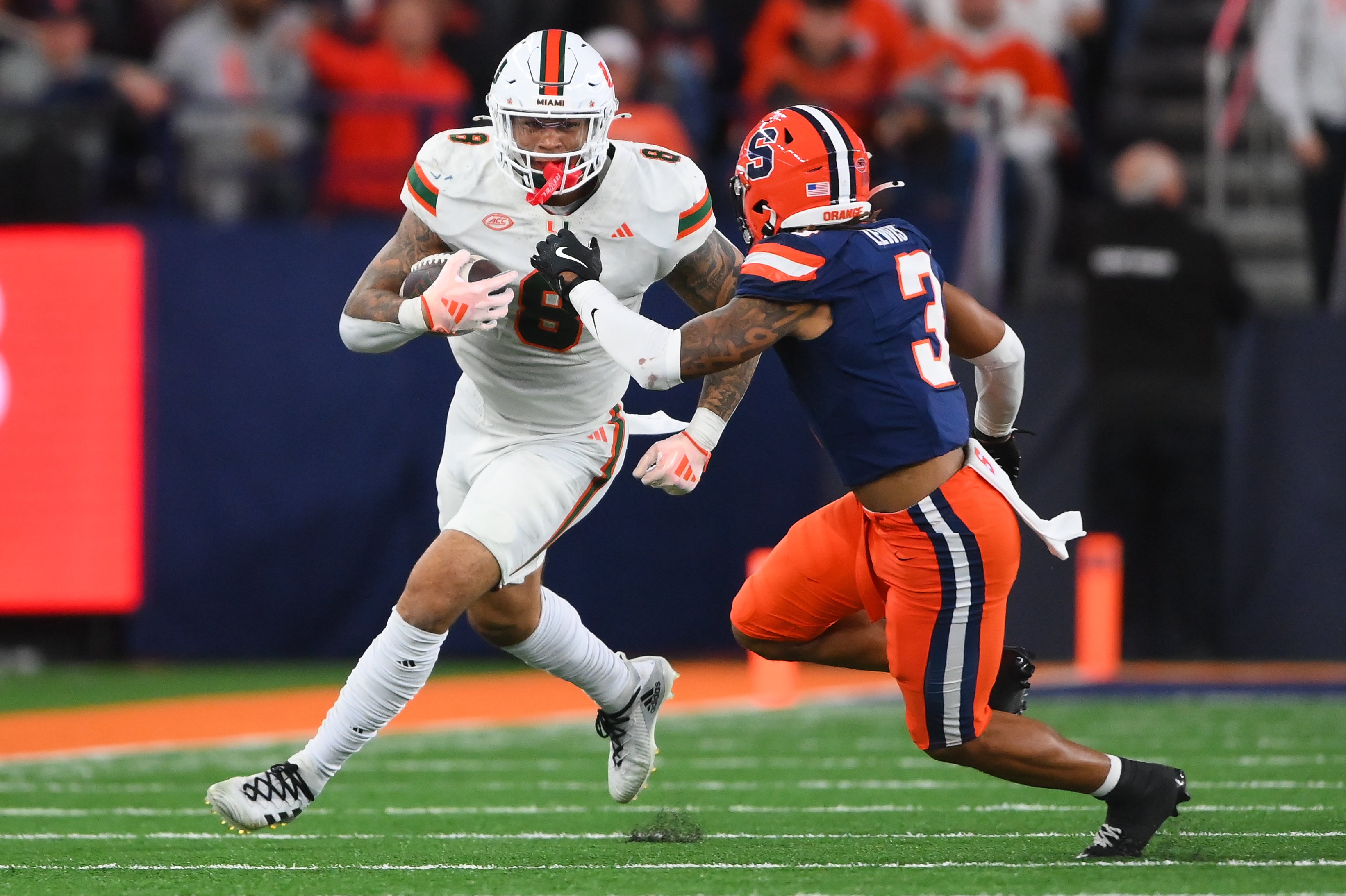 Nov 30, 2024; Syracuse, New York, USA; Miami Hurricanes tight end Elijah Arroyo (8) runs with the ball after a catch against Syracuse Orange defensive back Clarence Lewis (3) during the second half at the JMA Wireless Dome.