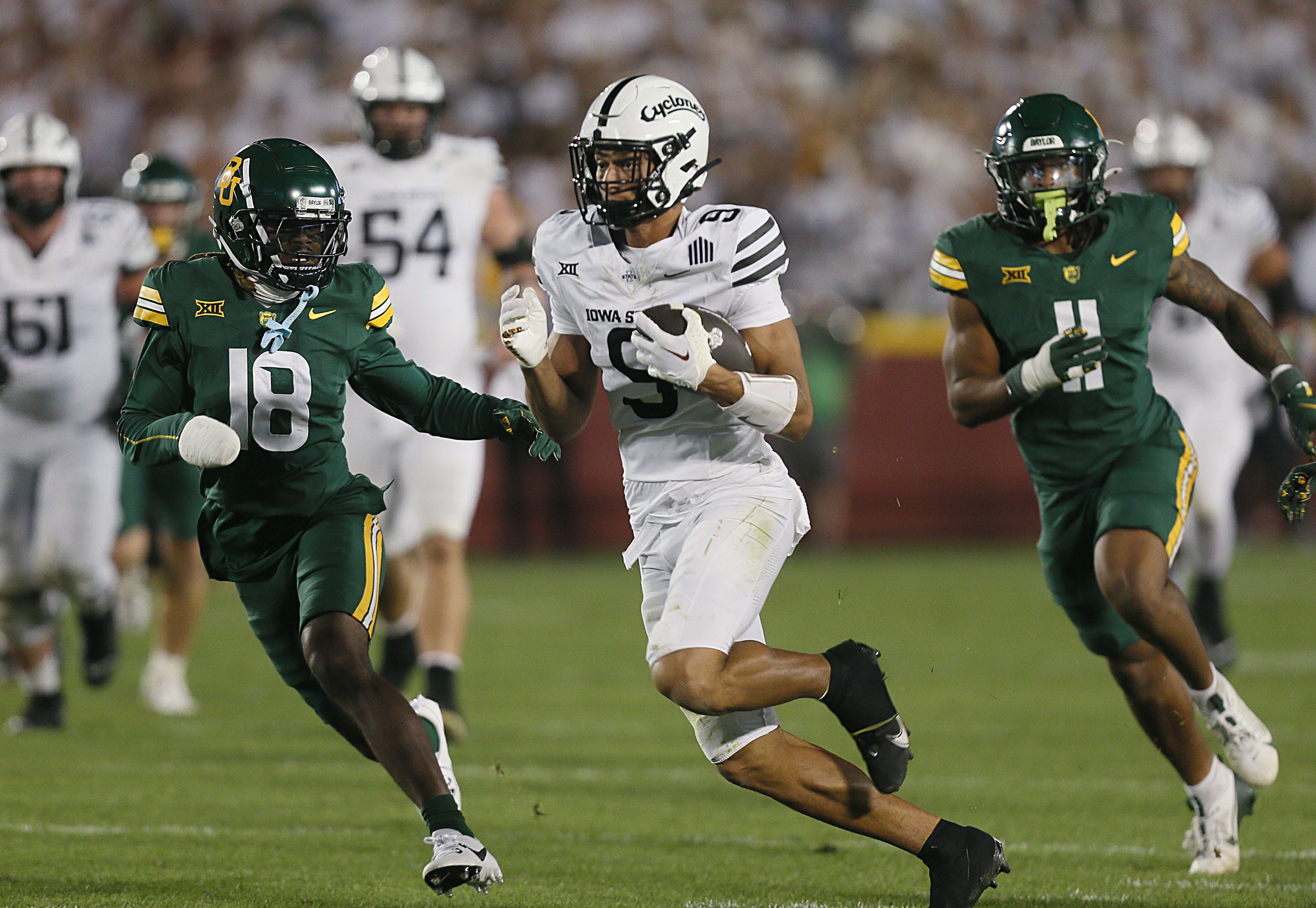 Iowa State Cyclones wide receiver Jayden Higgins (9) runs with the ball between Baylor Bears cornerback Lorando Johnson and Baylor Bears linebacker Keaton Thomas (11) after making a catch during the third quarter in the NCAA football at Jack Trice Stadium on Saturday, Oct. 5, 2024, in Ames, Iowa.