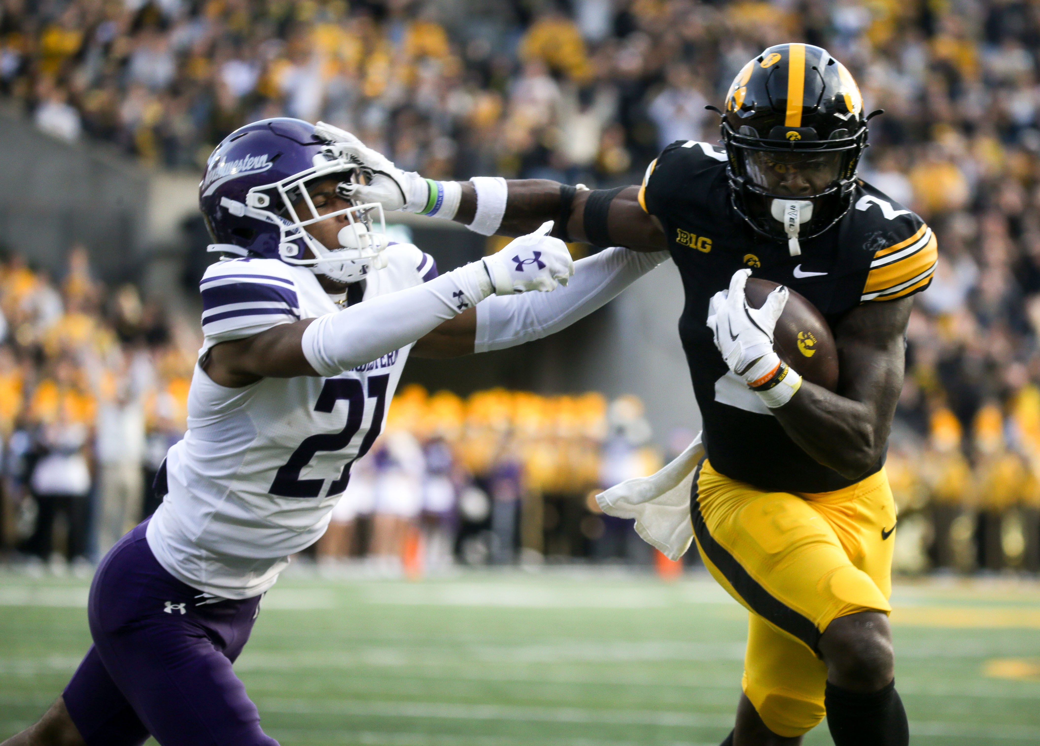 Iowa’s Kaleb Johnson (2) stiff arms Northwestern’s Jack Oyola (27) enroute to scoring a touchdown in the second quarter Saturday, Oct. 26, 2024 at Kinnick Stadium in Iowa City, Iowa.