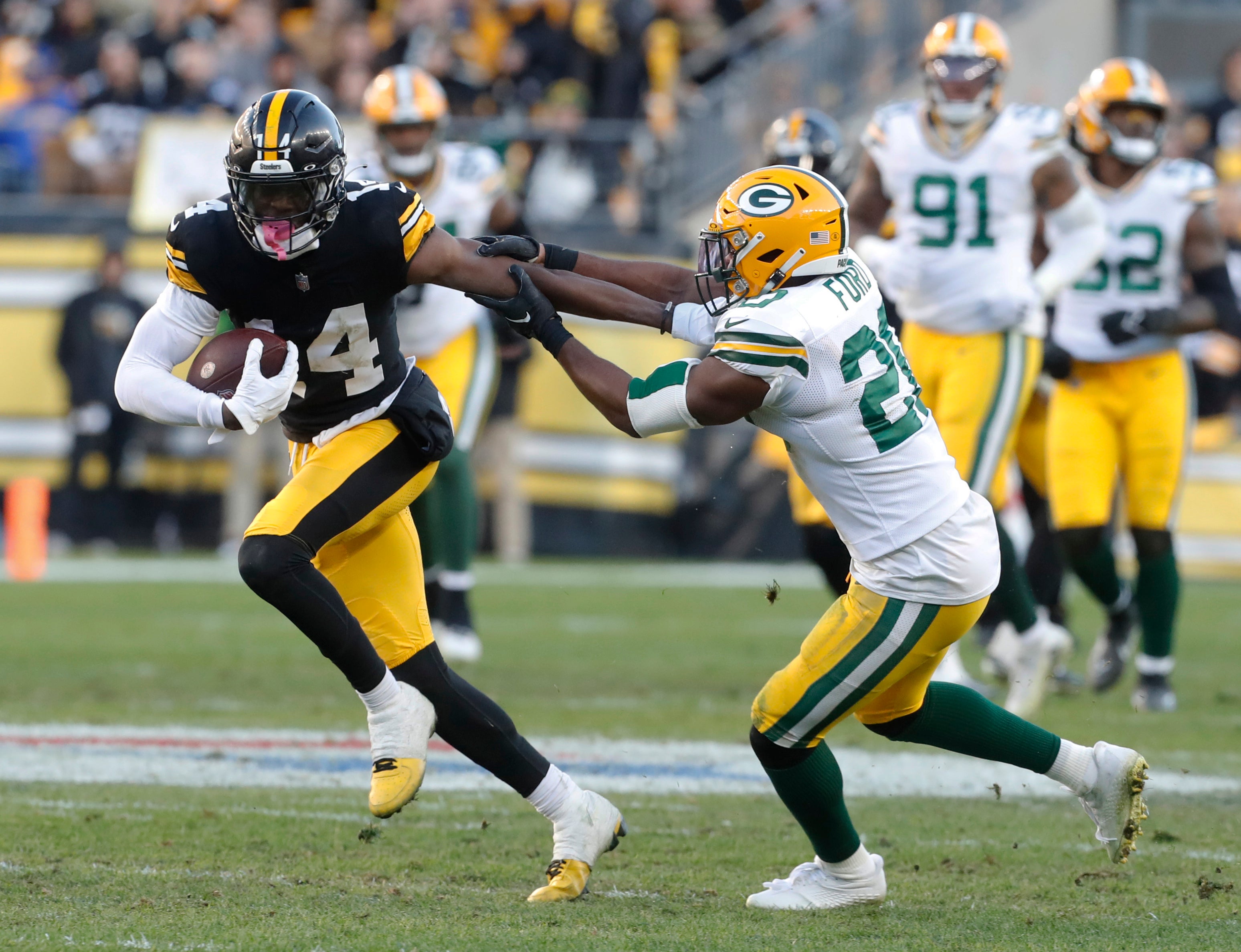 Nov 12, 2023; Pittsburgh, Pennsylvania, USA; Pittsburgh Steelers wide receiver George Pickens (14) runs after a catch against Green Bay Packers safety Rudy Ford (20) during the fourth quarter at Acrisure Stadium. Pittsburgh won 23-19.