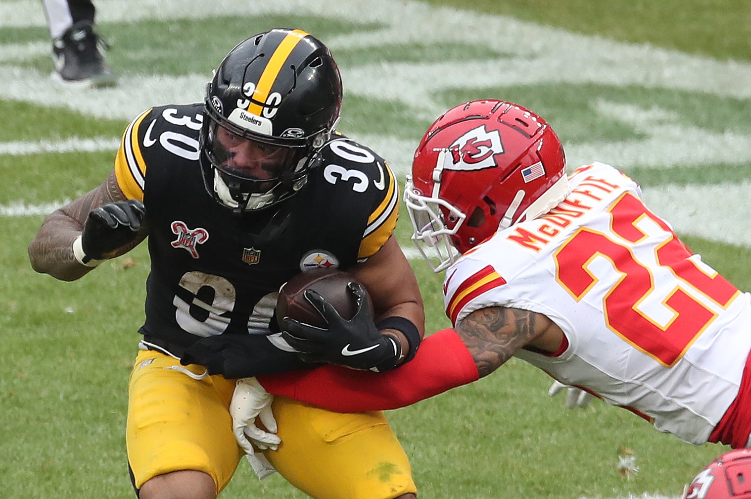 Dec 25, 2024; Pittsburgh, Pennsylvania, USA; Pittsburgh Steelers running back Jaylen Warren (30 carries the ball against Kansas City Chiefs cornerback Trent McDuffie (22) during the third quarter at Acrisure Stadium.