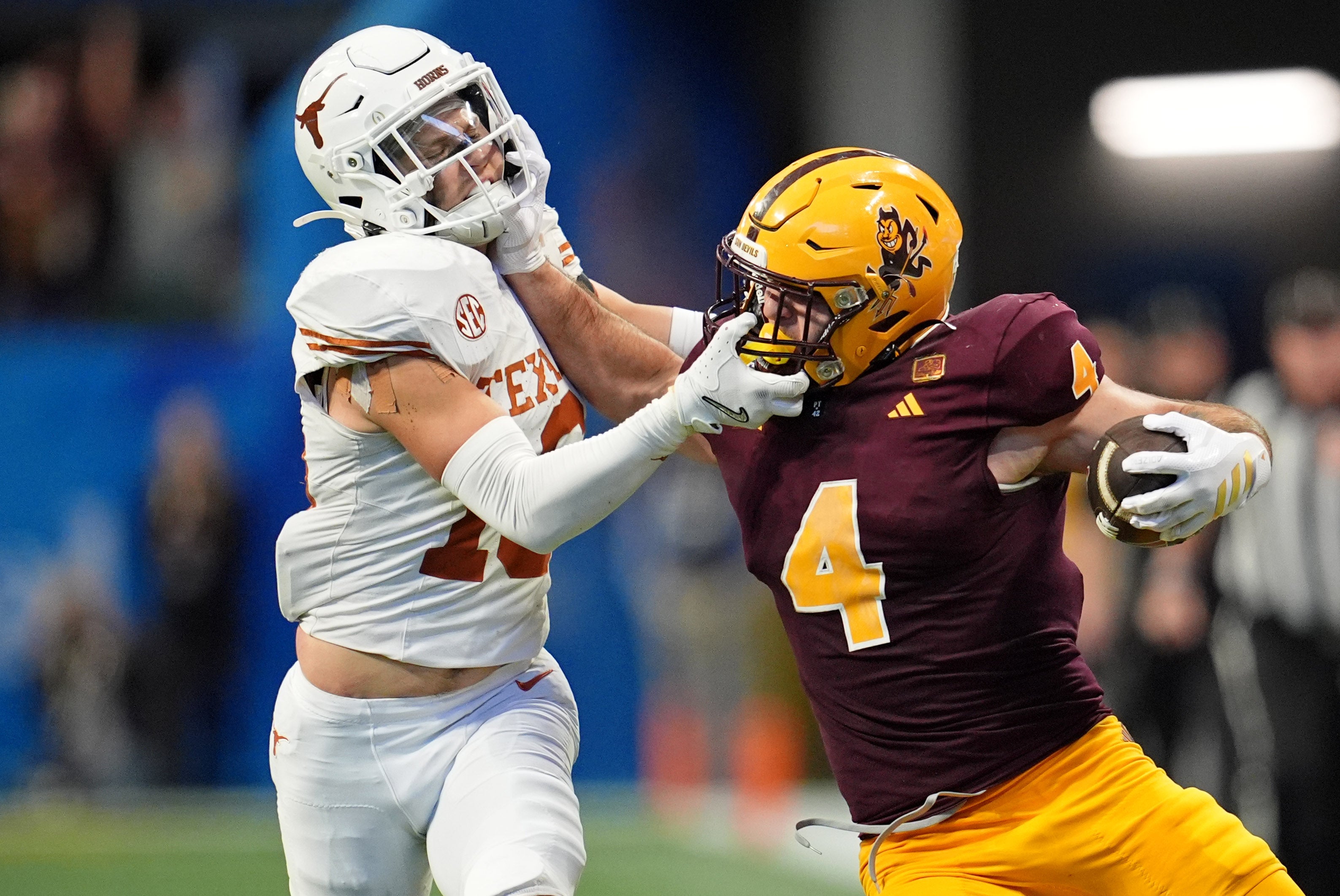 Jan 1, 2025; Atlanta, GA, USA; Arizona State Sun Devils running back Cam Skattebo (4) and Texas Longhorns defensive back Michael Taaffe (16) push each other during the second half of the Peach Bowl at Mercedes-Benz Stadium.