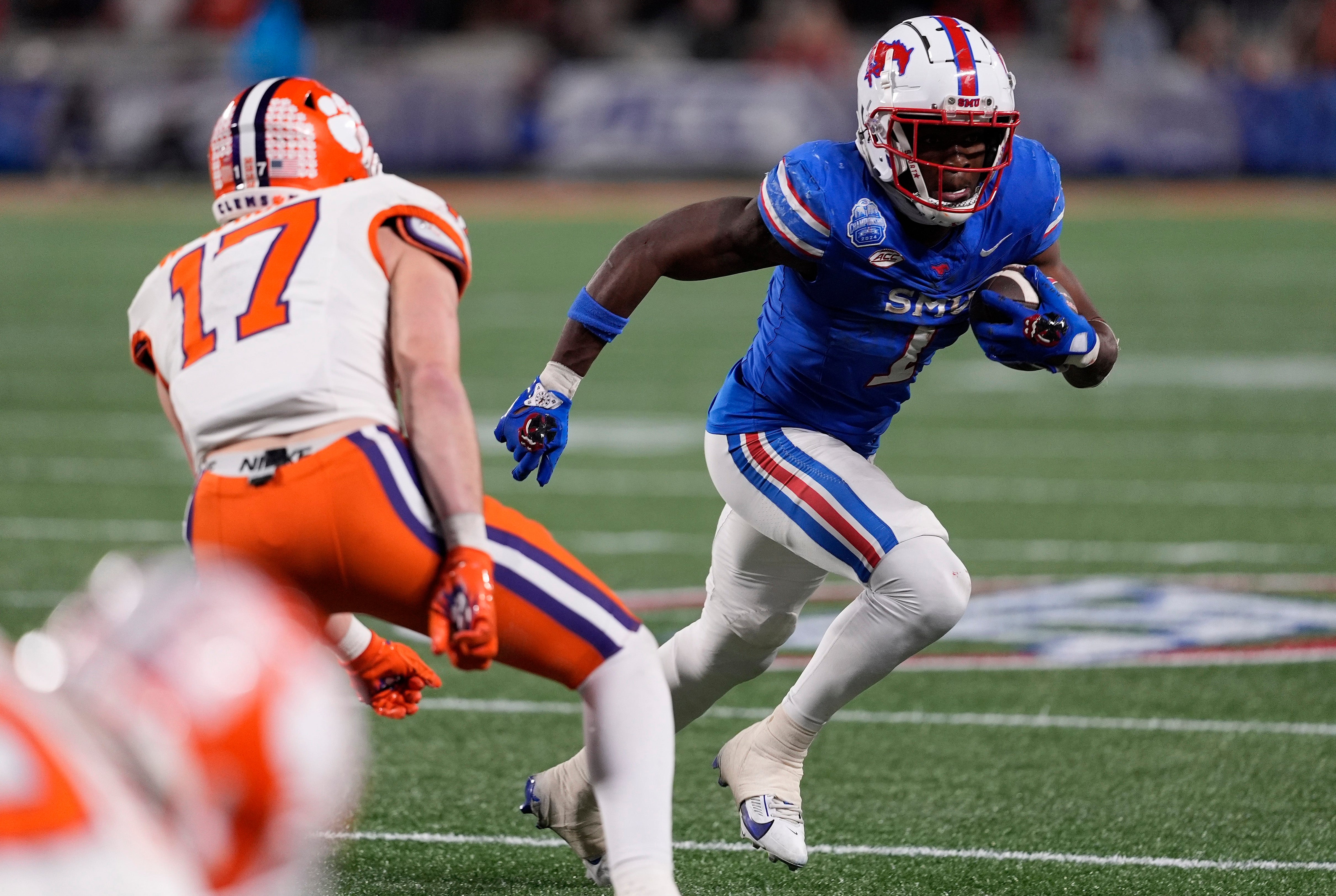 Dec 7, 2024; Charlotte, NC, USA; Southern Methodist Mustangs running back Brashard Smith (1) runs against Clemson Tigers linebacker Wade Woodaz (17) during the fourth quarter in the 2024 ACC Championship game at Bank of America Stadium.