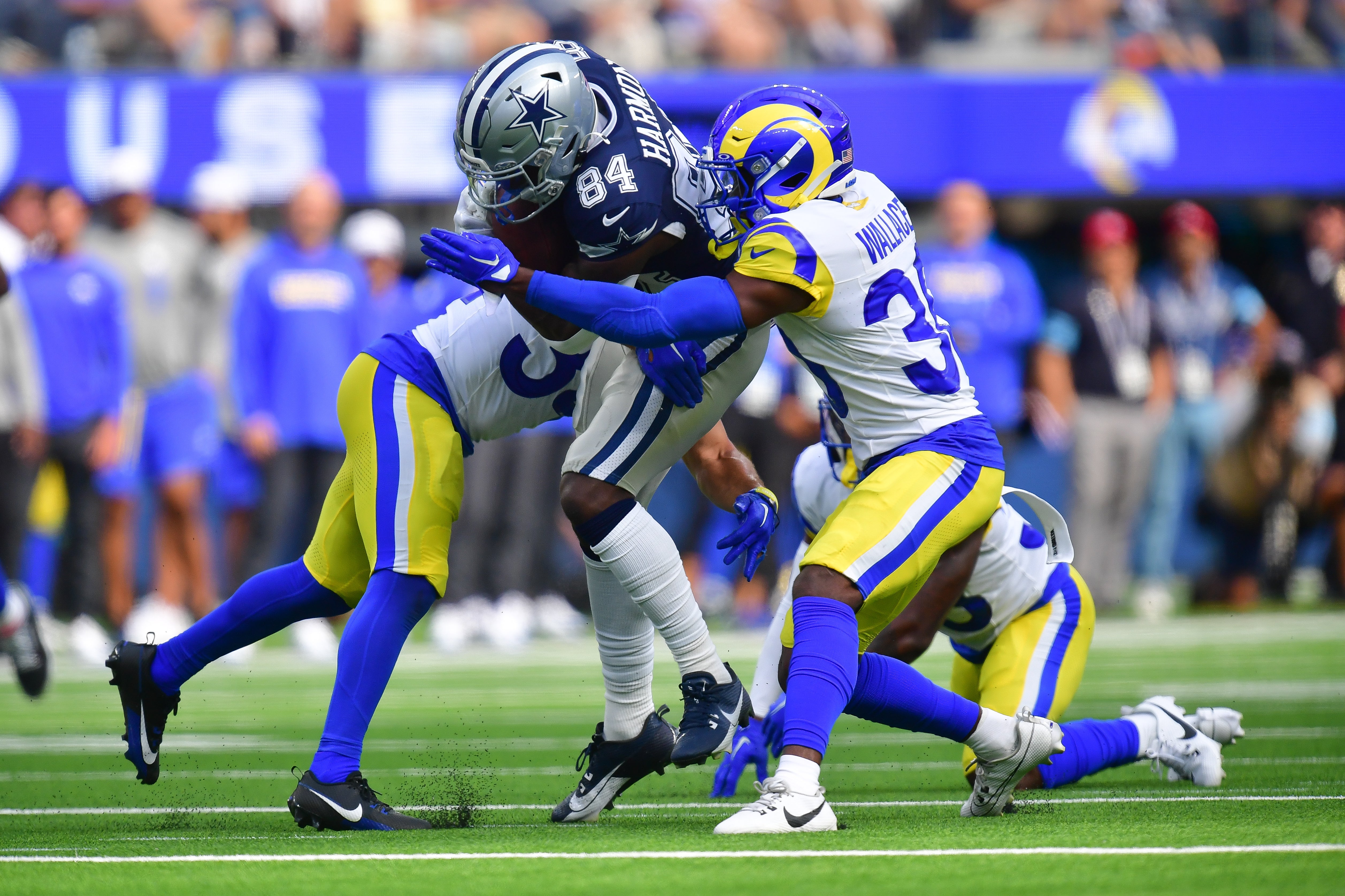 Dallas Cowboys wide receiver Kelvin Harmon (84) runs the ball against Los Angeles Rams cornerback Josh Wallace (30) during the second half at SoFi Stadium.