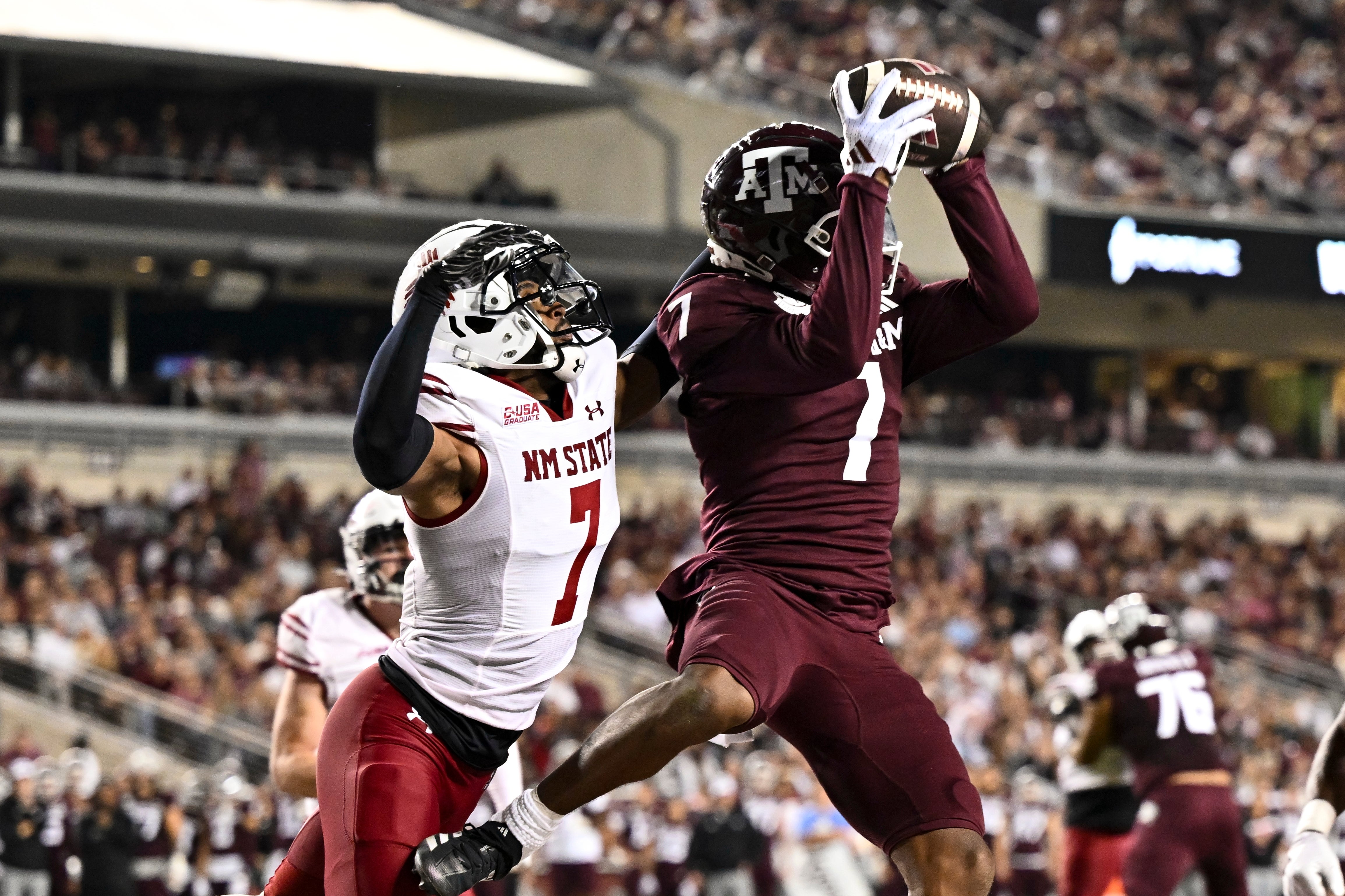 Nov 16, 2024; College Station, Texas, USA; Texas A&M Aggies wide receiver Moose Muhammad III (7) receives a pass for a touchdown as New Mexico State Aggies cornerback Keonte Glinton (7) defends during the second quarter at Kyle Field.