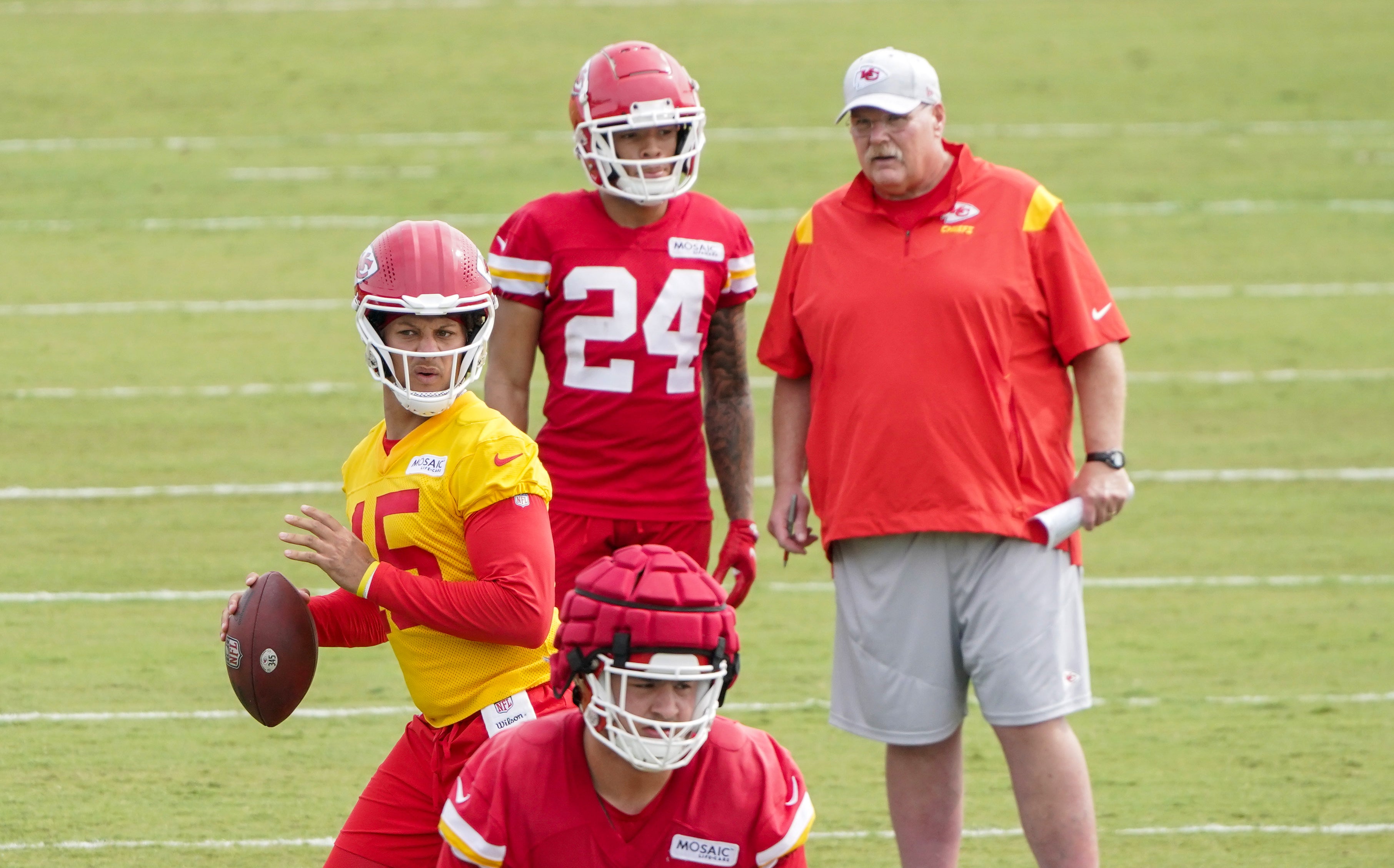 Jul 27, 2022; St. Joseph, MO, USA; Kansas City Chiefs quarterback Patrick Mahomes (15) drops back to pass as wide receiver Skyy Moore (24) talks with head coach Andy Reid during training camp at Missouri Western University.