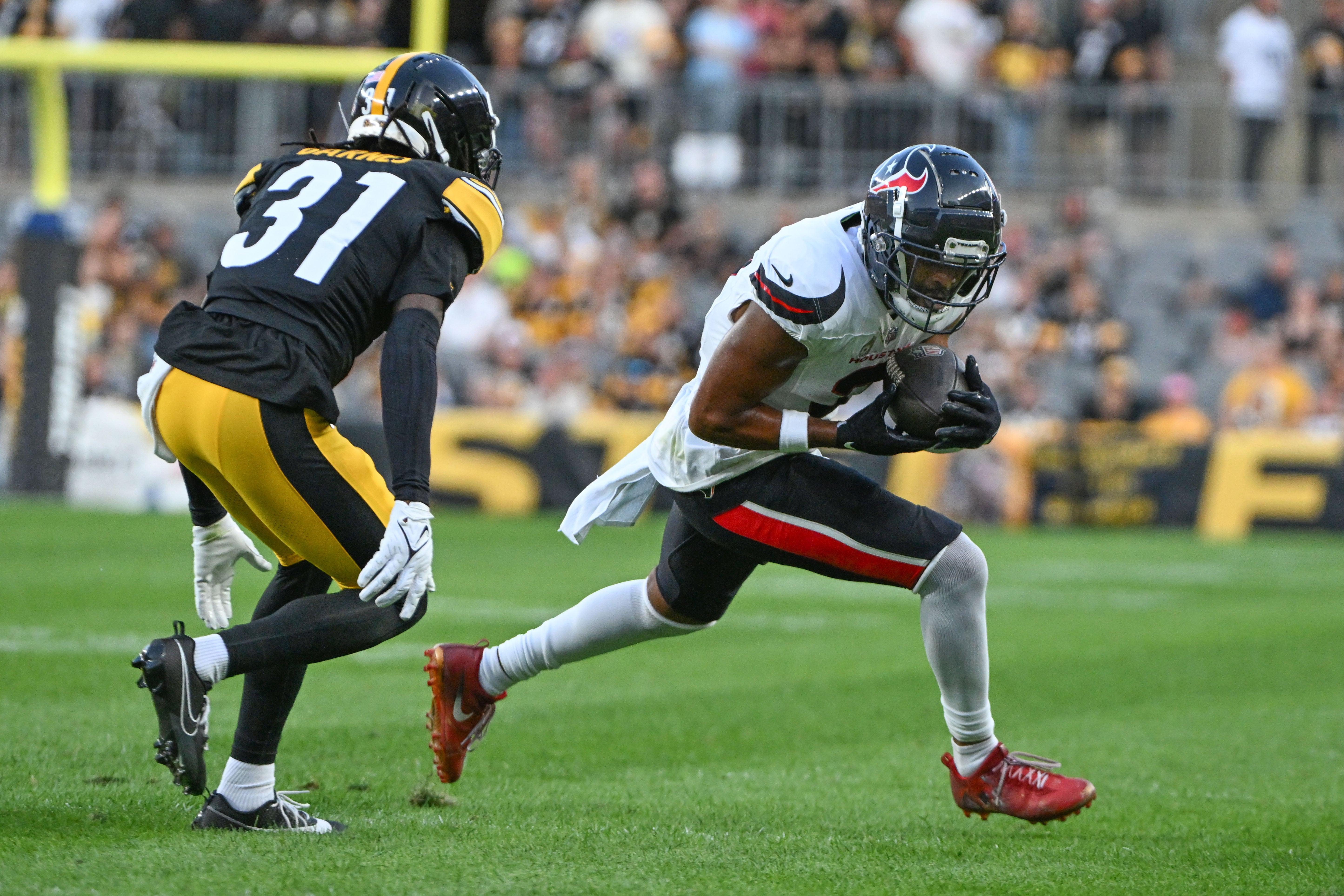 Aug 9, 2024; Pittsburgh, Pennsylvania, USA; Houston Texans wide receiver Robert Woods (2) gains yardage as Pittsburgh Steelers cornerback Kalon Barnes (31) defends during the second quarter at Acrisure Stadium.