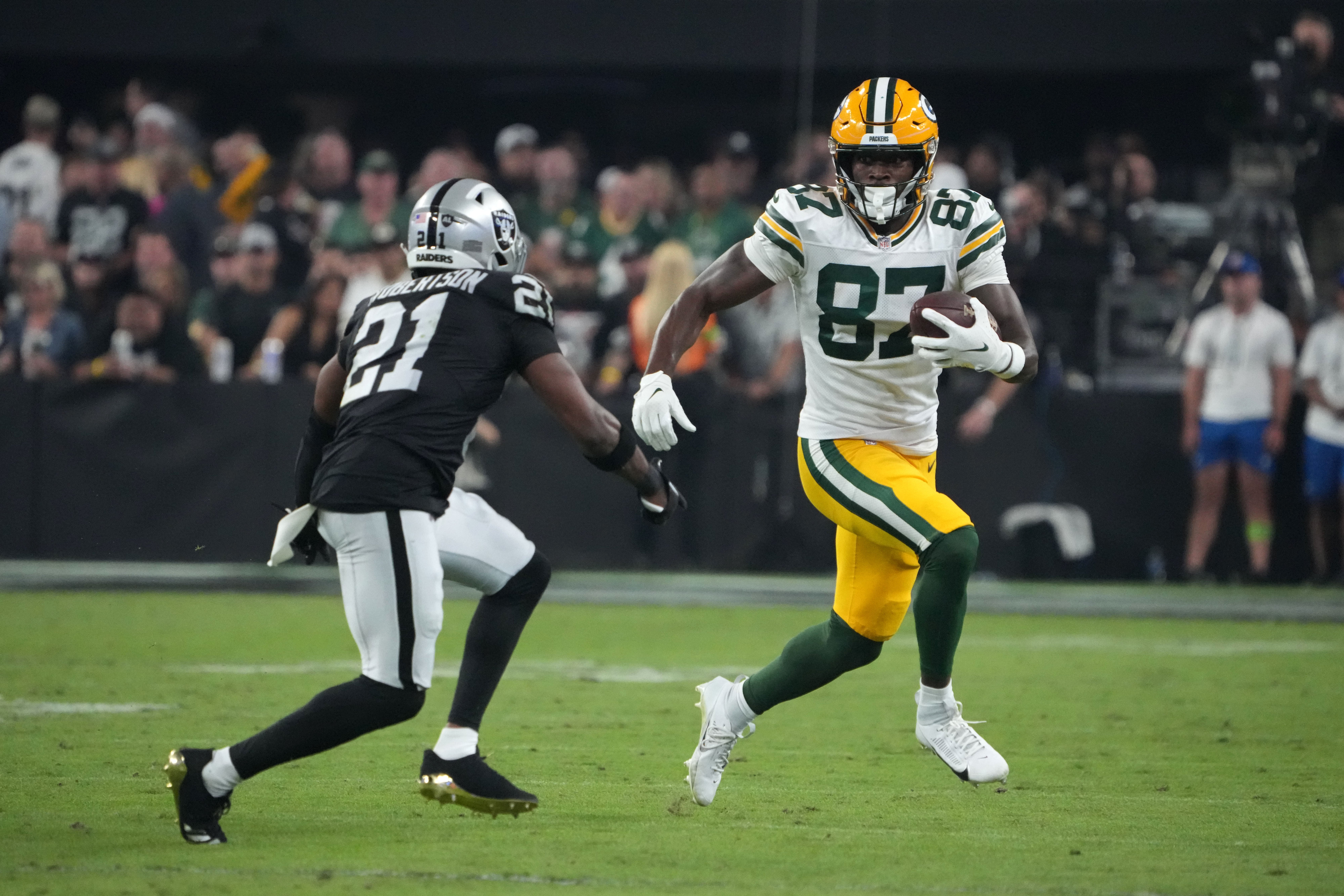 Green Bay Packers wide receiver Romeo Doubs (87) carries the ball against Las Vegas Raiders cornerback Amik Robertson (21) in the second half at Allegiant Stadium.