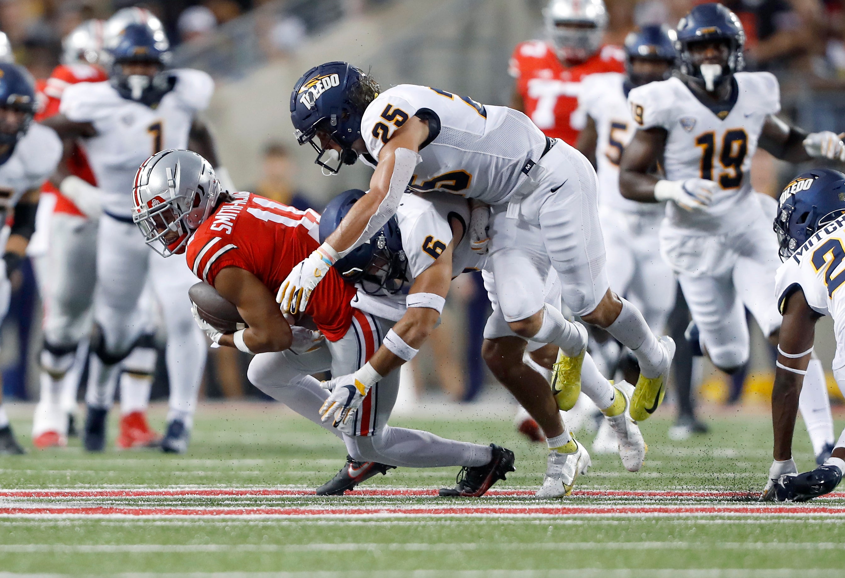 Ohio State Buckeyes wide receiver Jaxon Smith-Njigba (11) makes the catch as Toledo Rockets safety Nate Bauer (6) and safety Maxen Hook (25) make the tackle during the second quarter at Ohio Stadium.