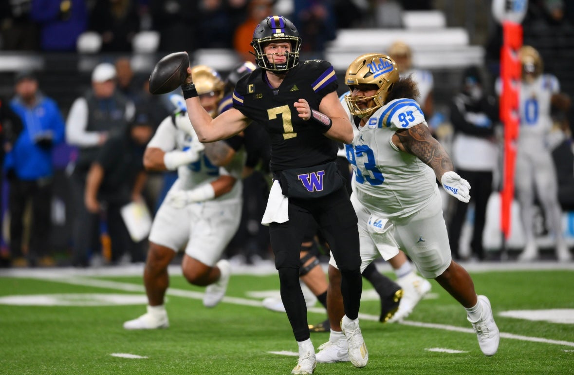 Nov 15, 2024; Seattle, Washington, USA; Washington Huskies quarterback Will Rogers (7) passes the ball before being tackled by UCLA Bruins defensive lineman Jay Toia (93) during the second half at Alaska Airlines Field at Husky Stadium. Mandatory Credit: Steven Bisig-Imagn Images