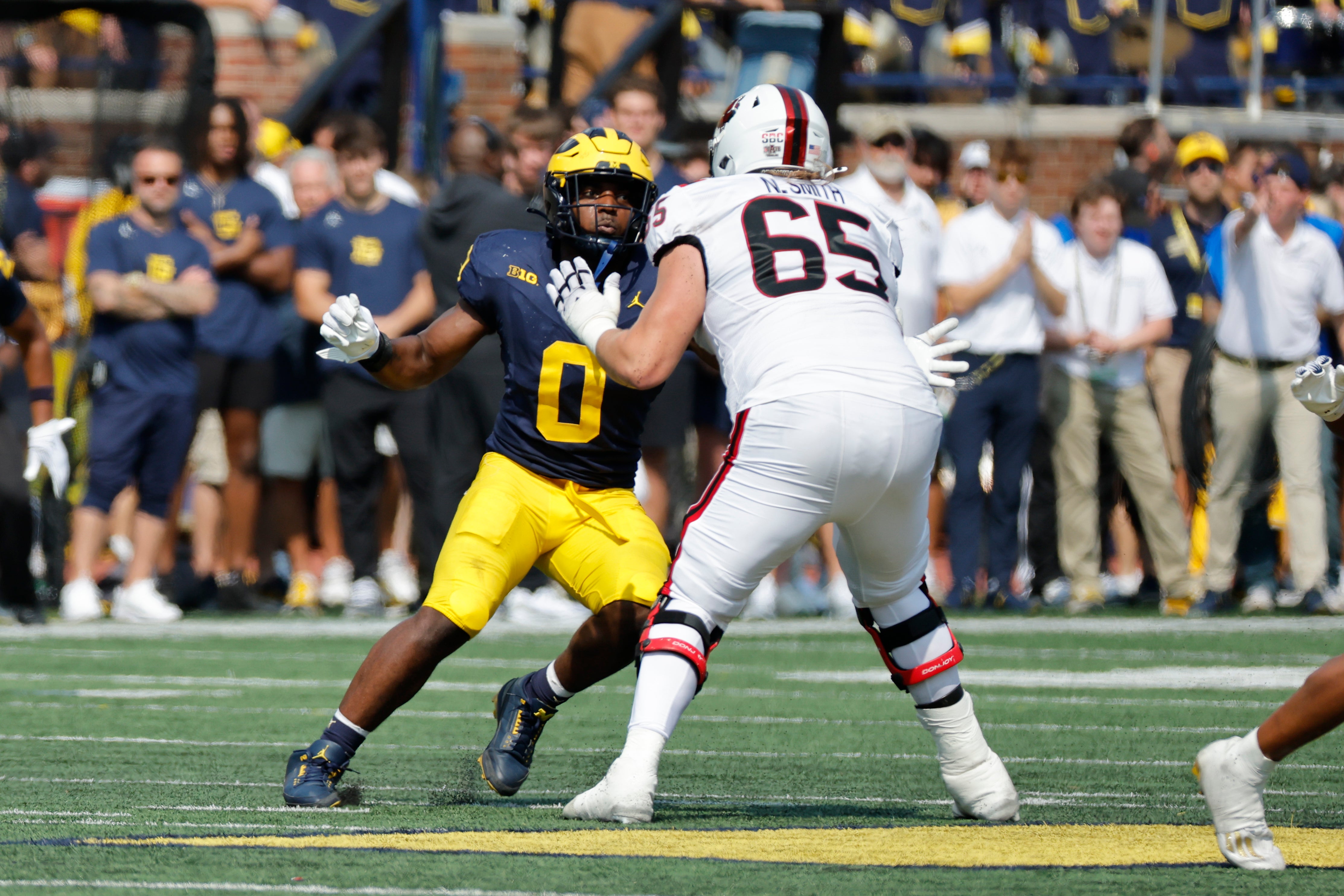 Sep 14, 2024; Ann Arbor, Michigan, USA; Michigan Wolverines defensive end Josaiah Stewart (0) rushes against Arkansas State Red Wolves offensive lineman Noah Smith (65) during the first half at Michigan Stadium.