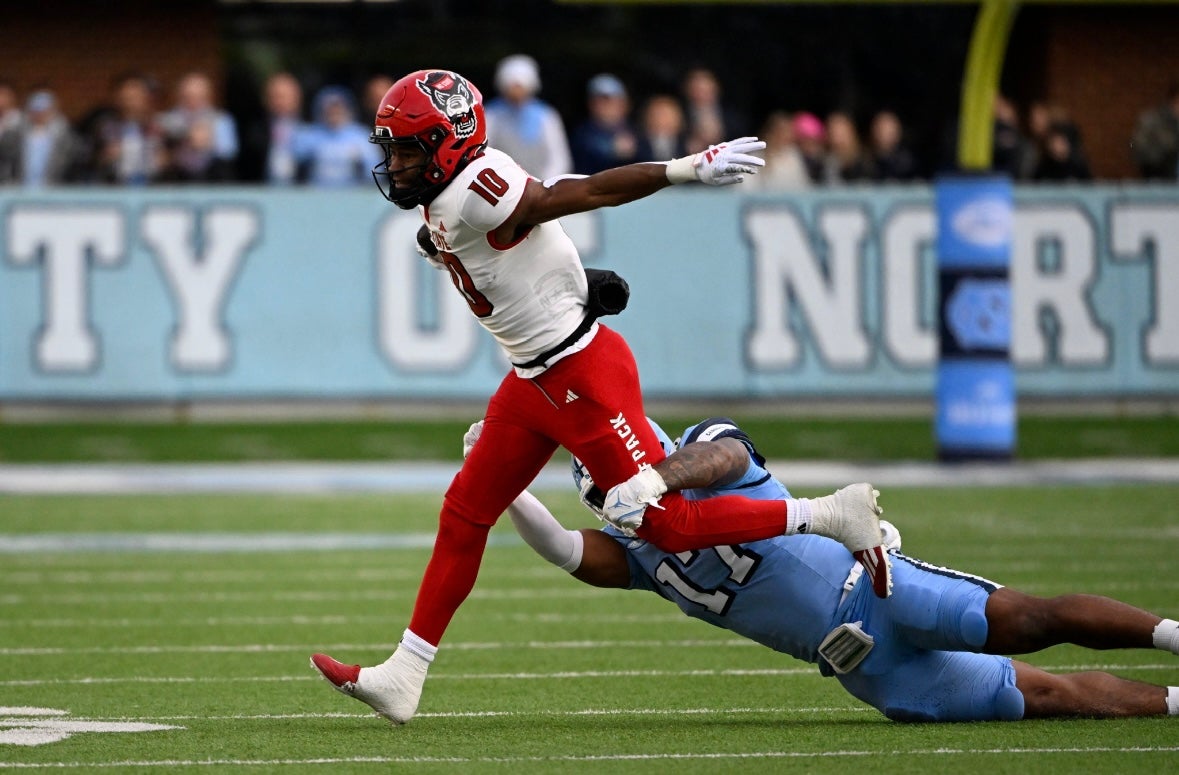 Nov 30, 2024; Chapel Hill, North Carolina, USA; North Carolina State Wolfpack wide receiver Kevin Concepcion (10) with the ball as North Carolina Tar Heels linebacker Amare Campbell (17) defends in the first quarter at Kenan Memorial Stadium. Mandatory Credit: Bob Donnan-Imagn Images