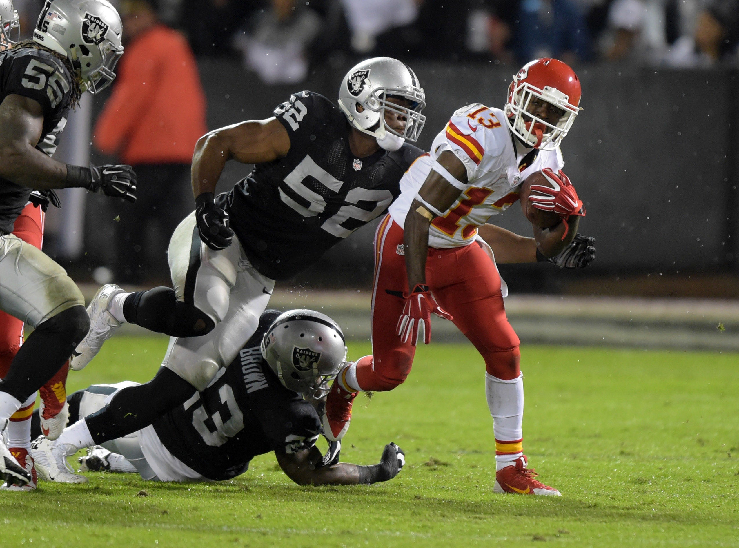 Nov 20, 2014; Oakland, CA, USA; Oakland Raiders linebacker Khalil Mack (52) and cornerback Tarell Brown (23) tackle Kansas City Chiefs running back DeAnthony Thomas (13) at O.co Coliseum.