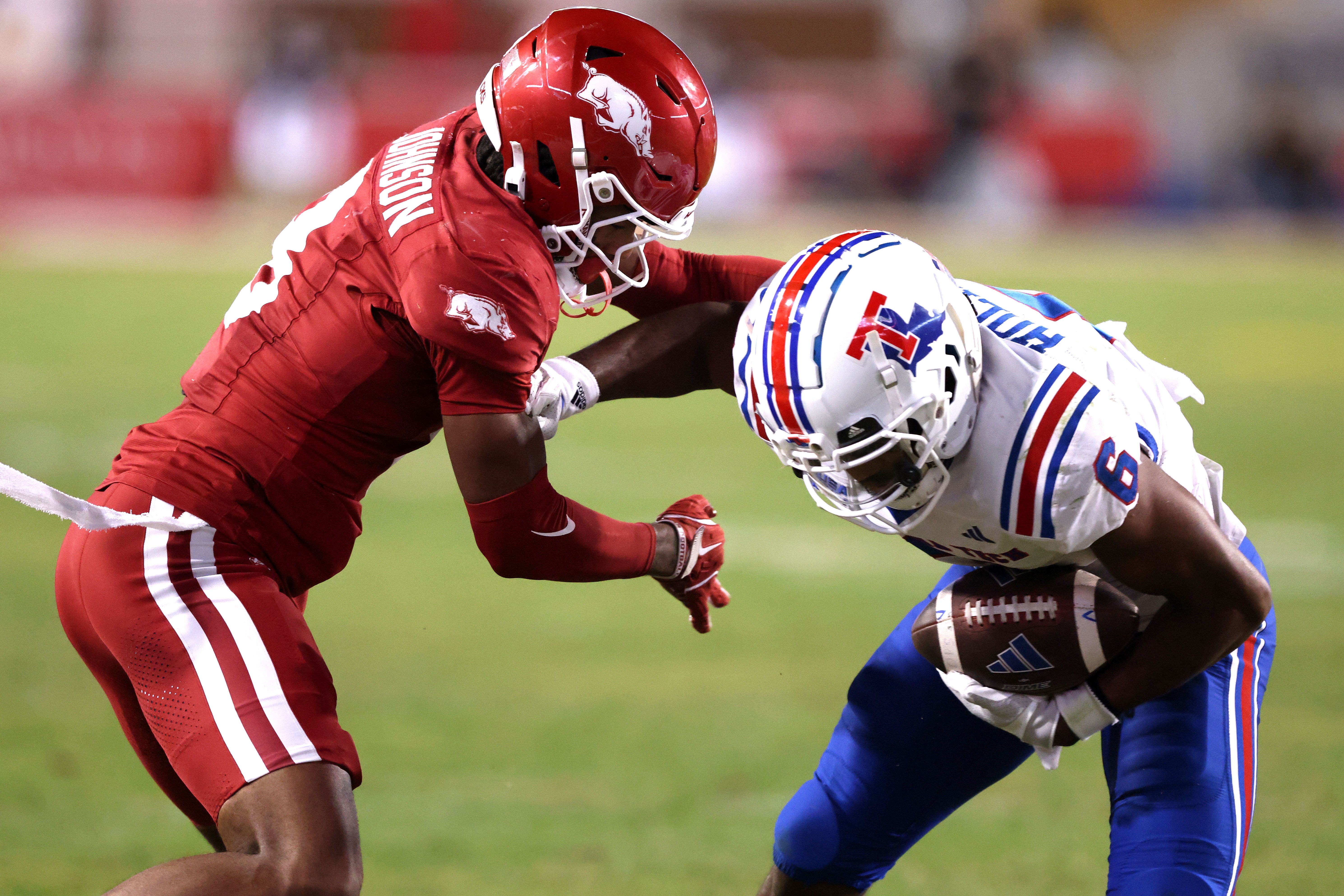 Nov 23, 2024; Fayetteville, Arkansas, USA; Arkansas Razorbacks defensive back Jayden Johnson (8) tackles Louisiana Tech Bulldogs wide receiver Jimmy Holiday (6) during the fourth quarter at Donald W. Reynolds Razorback Stadium. Arkansas won 35-14.