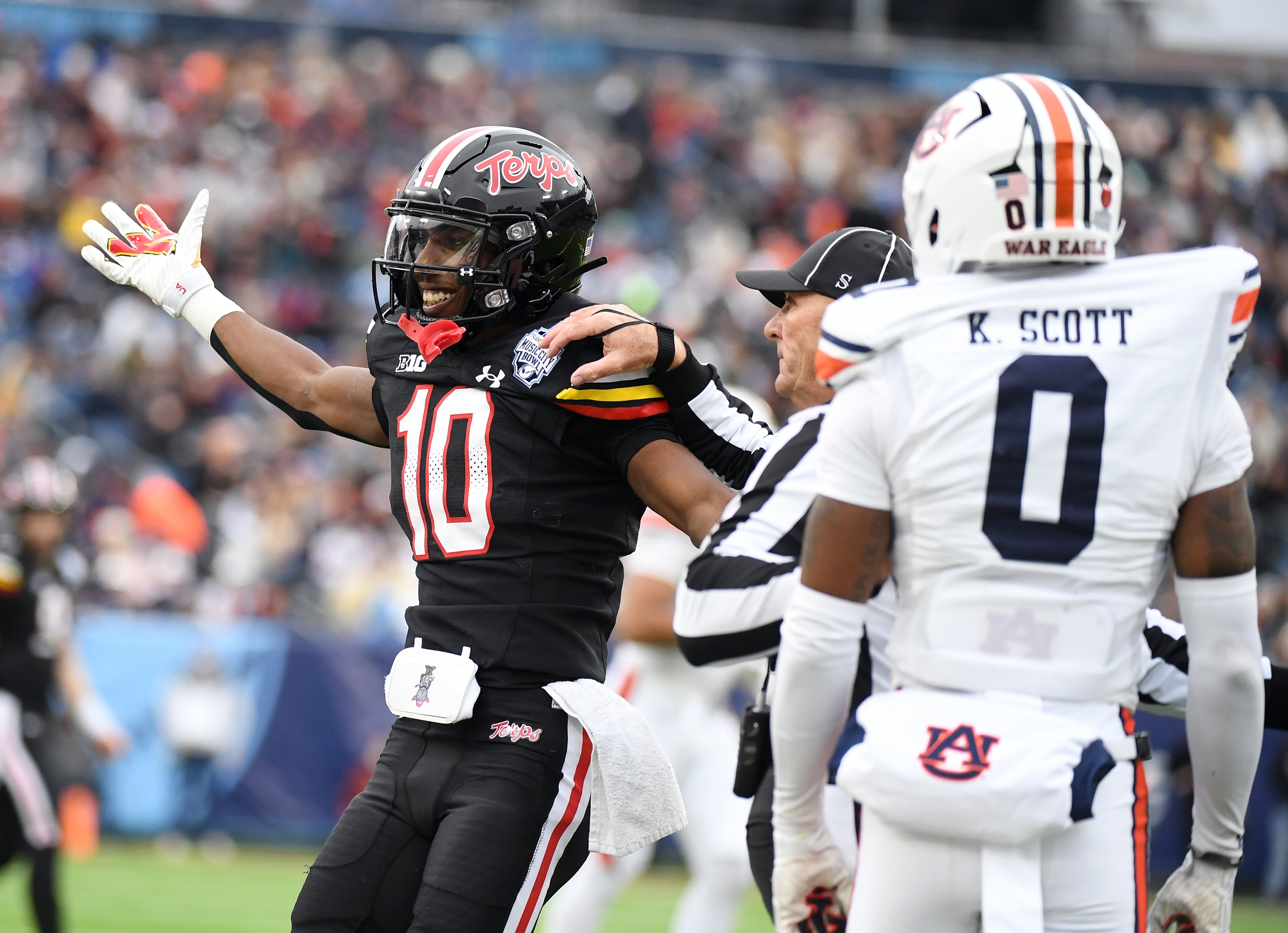 Dec 30, 2023; Nashville, TN, USA; Maryland Terrapins wide receiver Tai Felton (10) and Auburn Tigers cornerback Keionte Scott (0) have to be separated after a play during the first half at Nissan Stadium. Mandatory Credit: Christopher Hanewinckel-Imagn Images