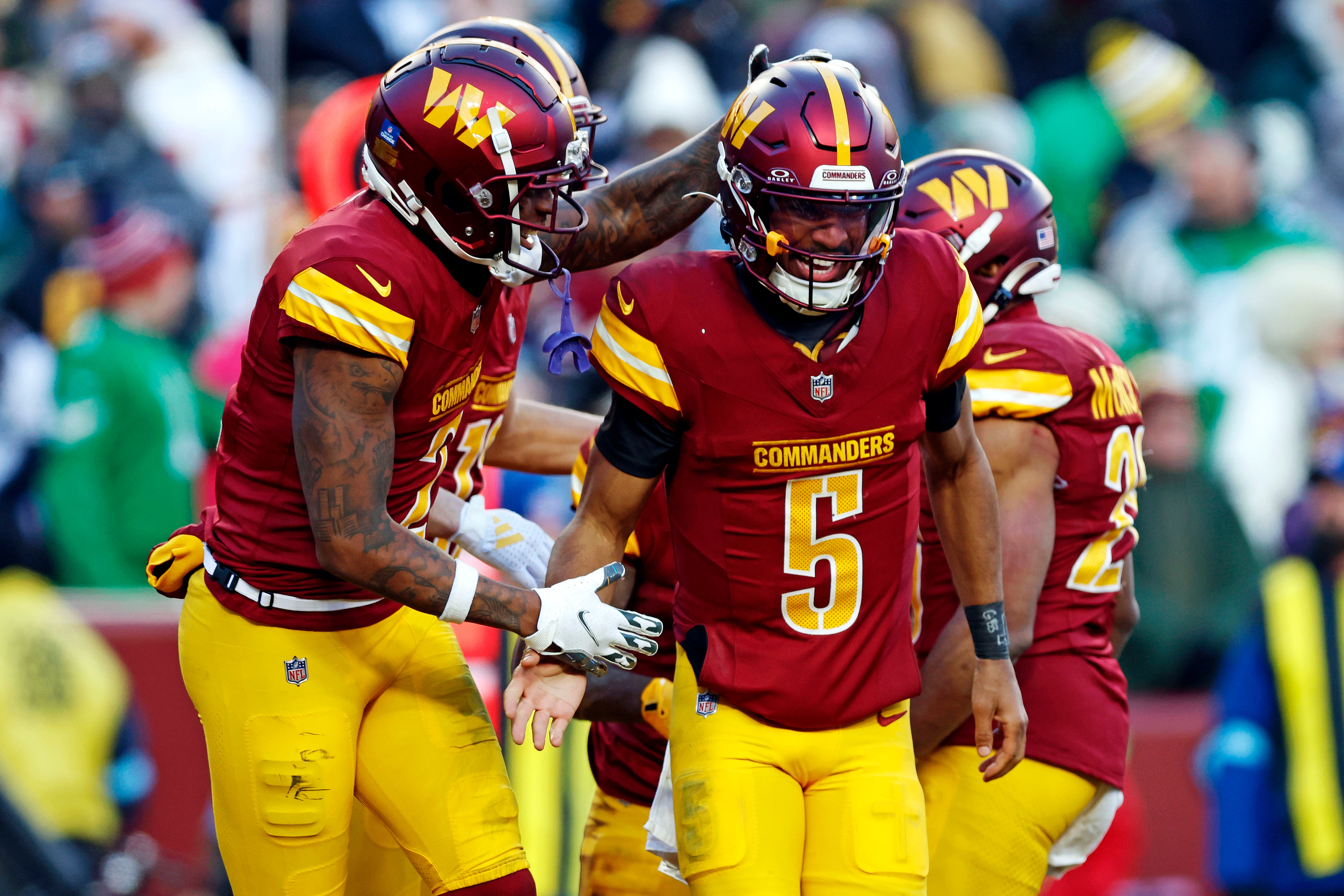 Dec 22, 2024; Landover, Maryland, USA; Washington Commanders quarterback Jayden Daniels (5) celebrates after throwing a touchdown pass during the fourth quarter against the Philadelphia Eagles at Northwest Stadium.