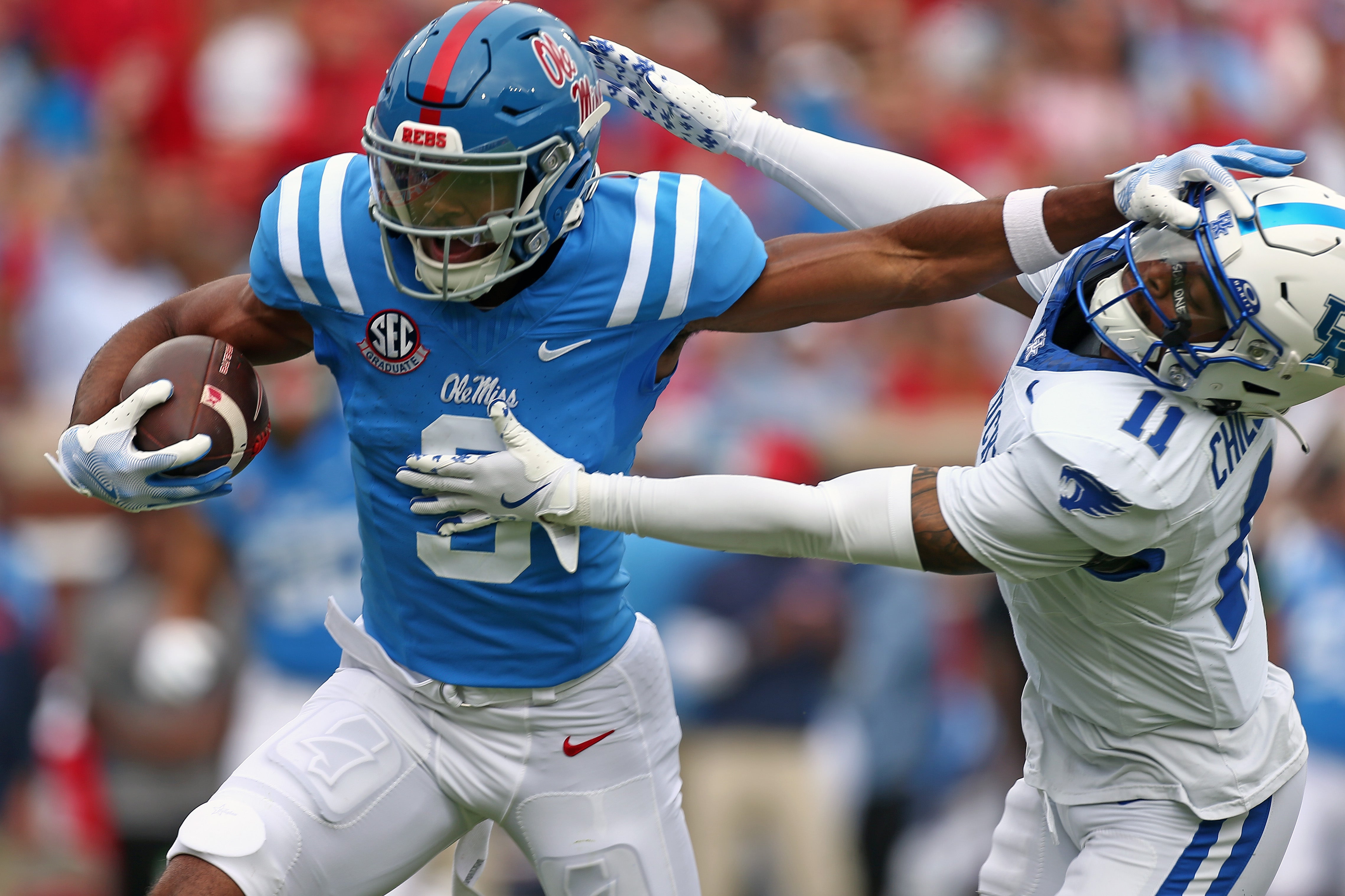 Sep 28, 2024; Oxford, Mississippi, USA; Mississippi Rebels wide receiver Tre Harris (9) stiff arms Kentucky Wildcats defensive back Zion Childress (11) during the first half at Vaught-Hemingway Stadium.