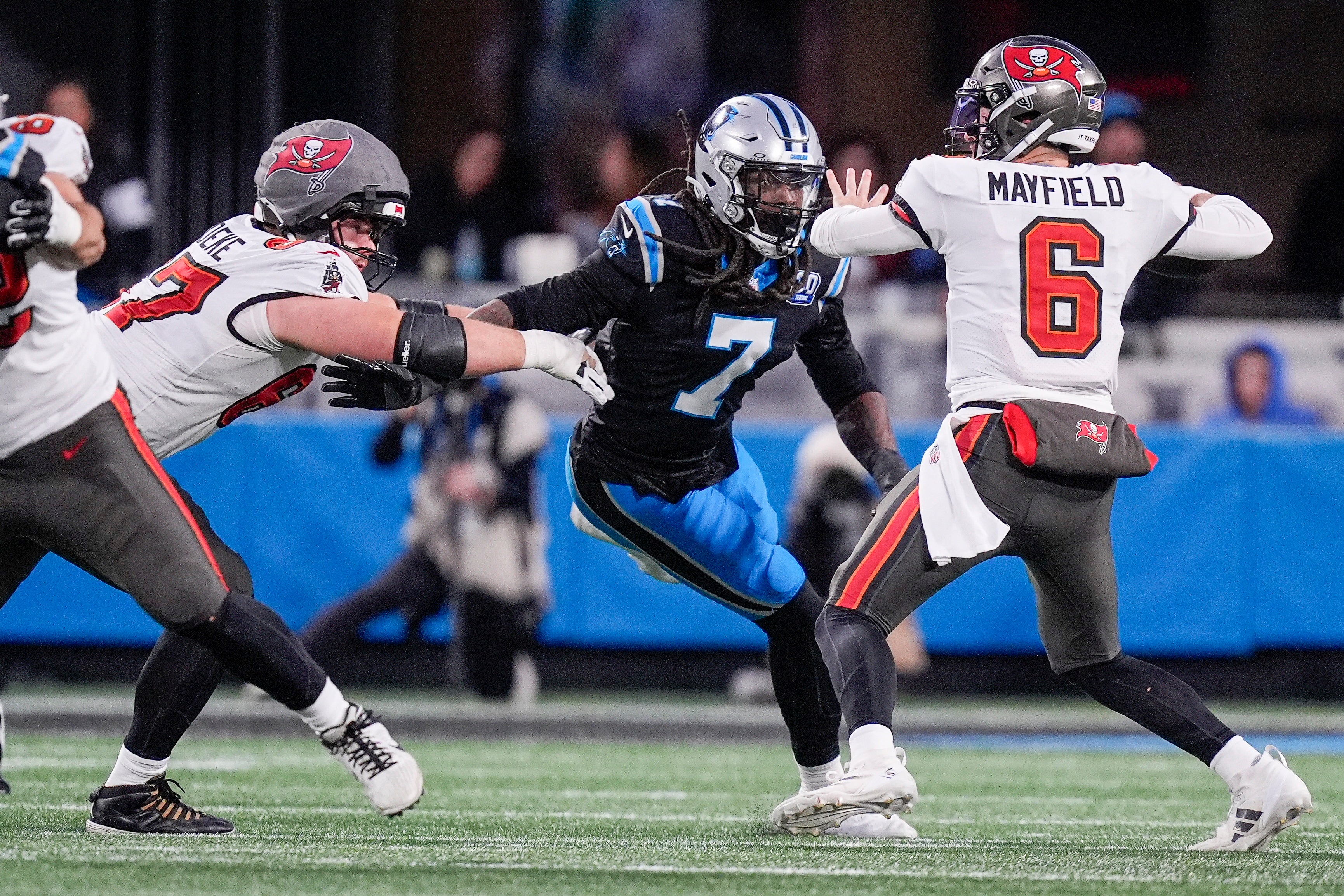 Dec 1, 2024; Charlotte, North Carolina, USA; Tampa Bay Buccaneers quarterback Baker Mayfield (6) throws under pressure from Carolina Panthers linebacker Jadeveon Clowney (7) during the second quarter at Bank of America Stadium.