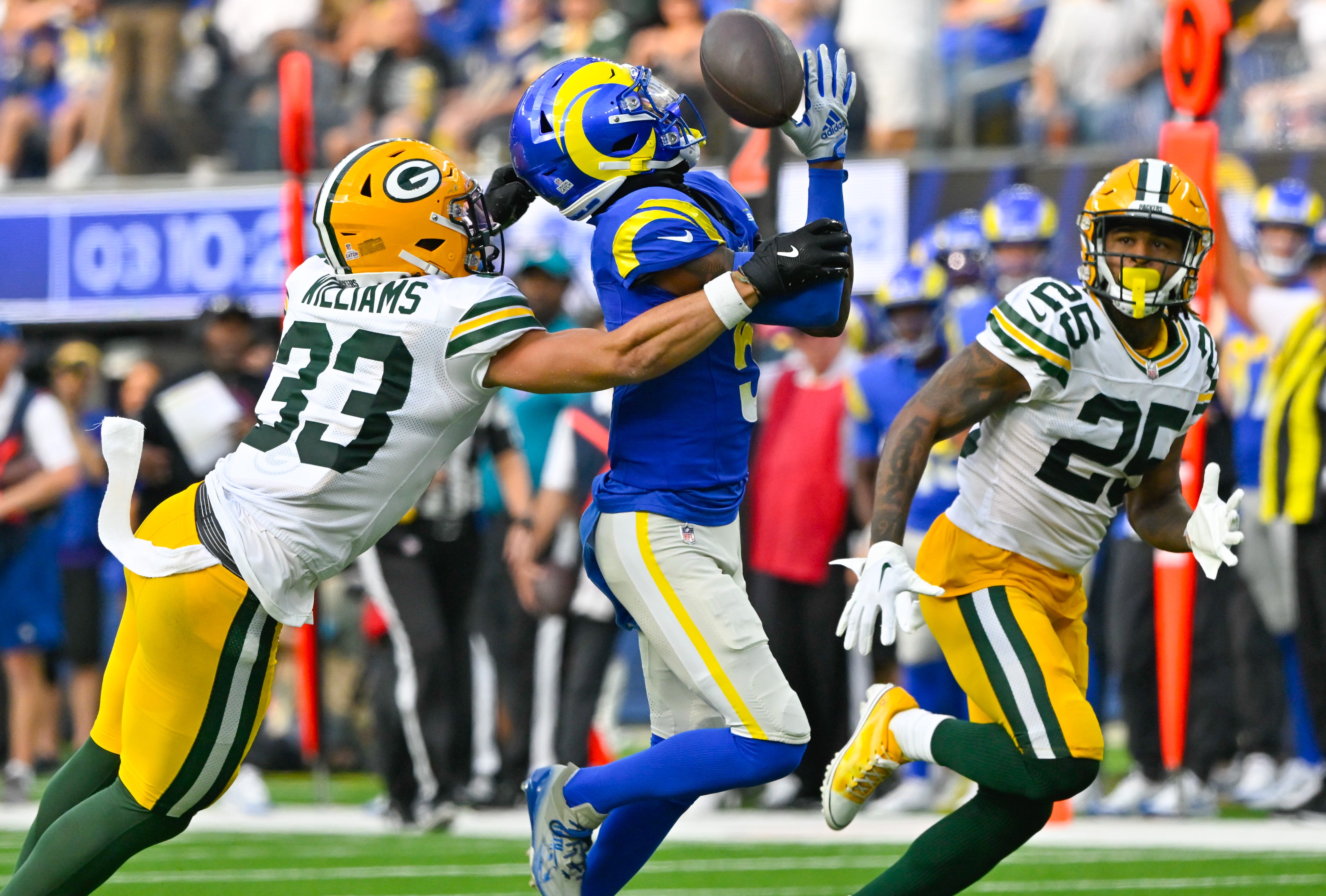 Oct 6, 2024; Inglewood, California, USA; Green Bay Packers safety Evan Williams (33) breaks up a pass to Los Angeles Rams wide receiver Tutu Atwell (5) during the third quarter at SoFi Stadium. Right is Green Bay Packers cornerback Keisean Nixon (25).