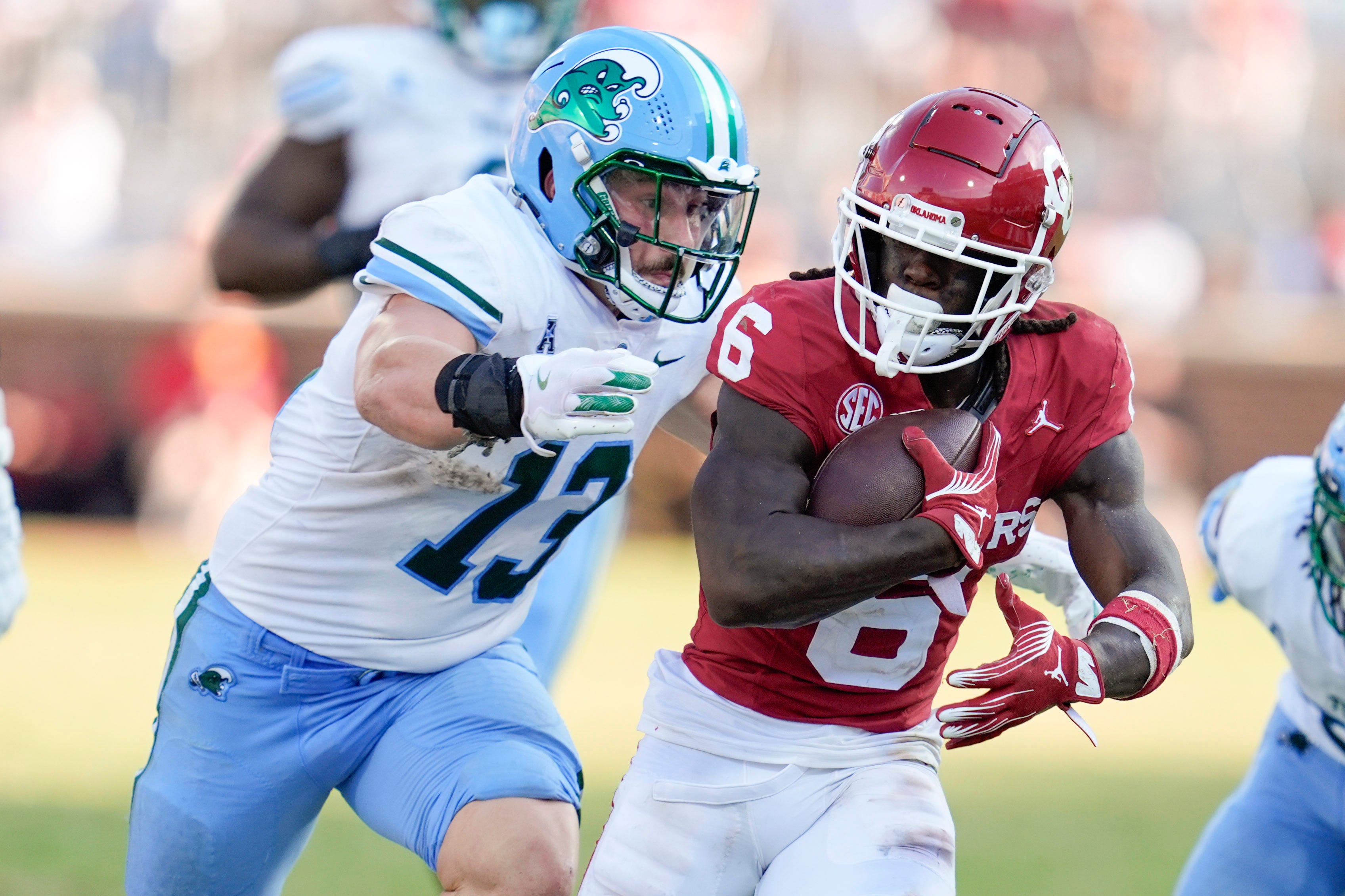 Oklahoma Sooners wide receiver Deion Burks (6) runs past Tulane Green Wave linebacker Tyler Grubbs (13) during a college football game between the University of Oklahoma Sooners (OU) and the Tulane Green Wave at Gaylord Family - Oklahoma Memorial Stadium in Norman, Okla., Saturday, Sept. 14, 2024.