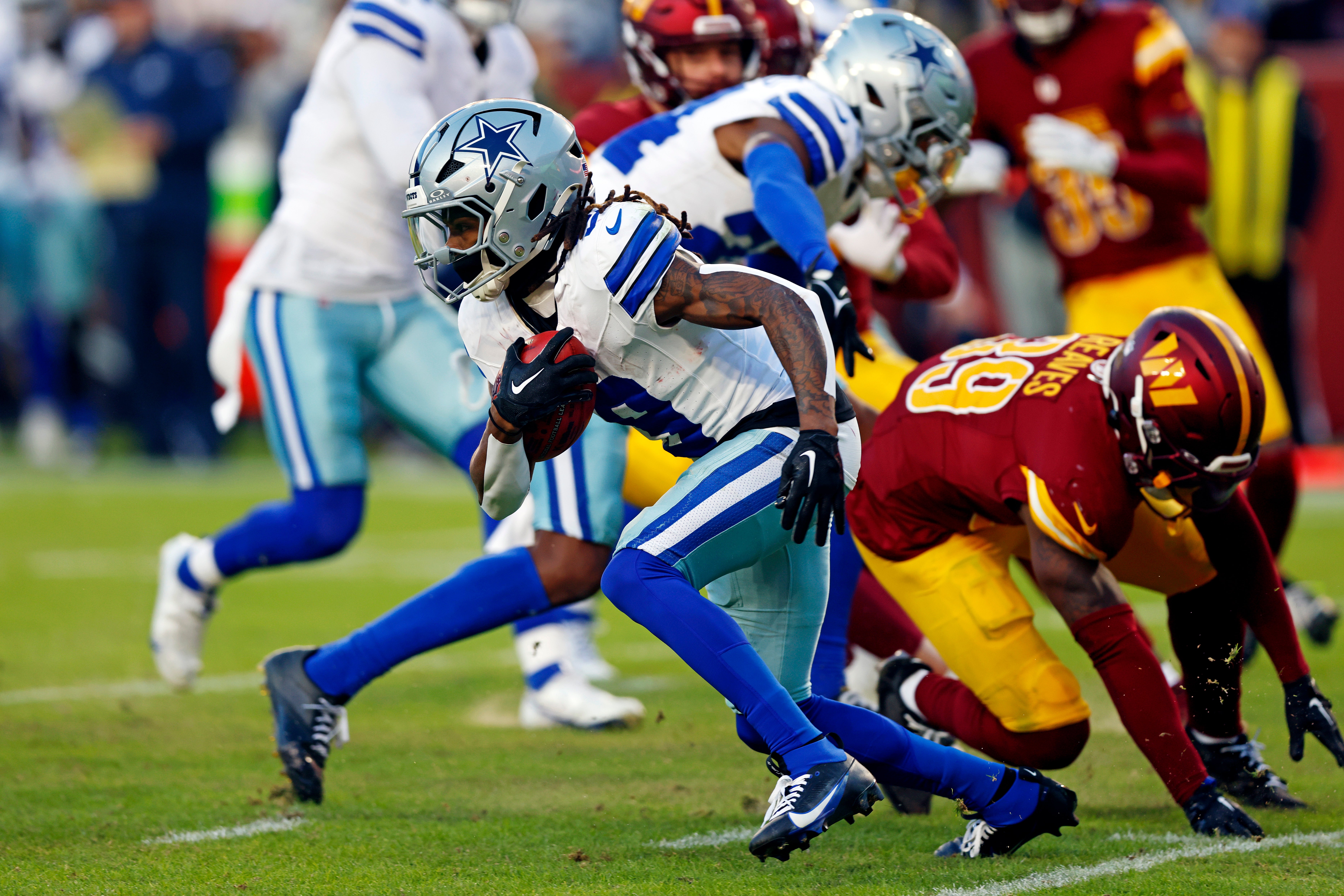 Dallas Cowboys wide receiver KaVontae Turpin (9) breaks a tackle by Washington Commanders safety Jeremy Reaves (39) to run for a touchdown on a kickoff return during the fourth quarter at Northwest Stadium.