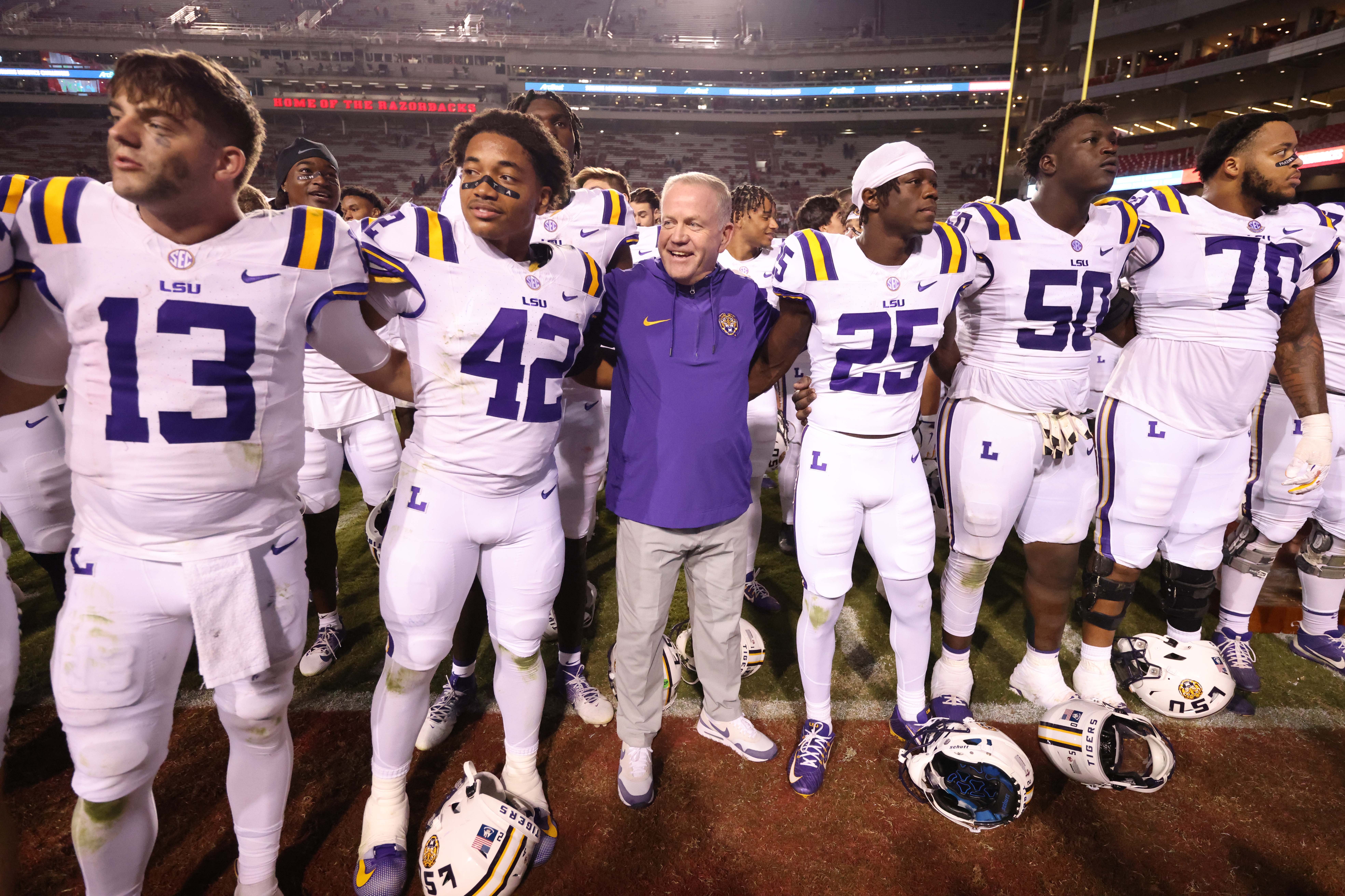 Oct 19, 2024; Fayetteville, Arkansas, USA; LSU Tigers quarterback Garrett Nussmeier (13) along with teammates and head coach Brian Kelly sing the LSU alma mater after a game against the Arkansas Razorbacks at Donald W. Reynolds Razorback Stadium. LSU won 34-10.