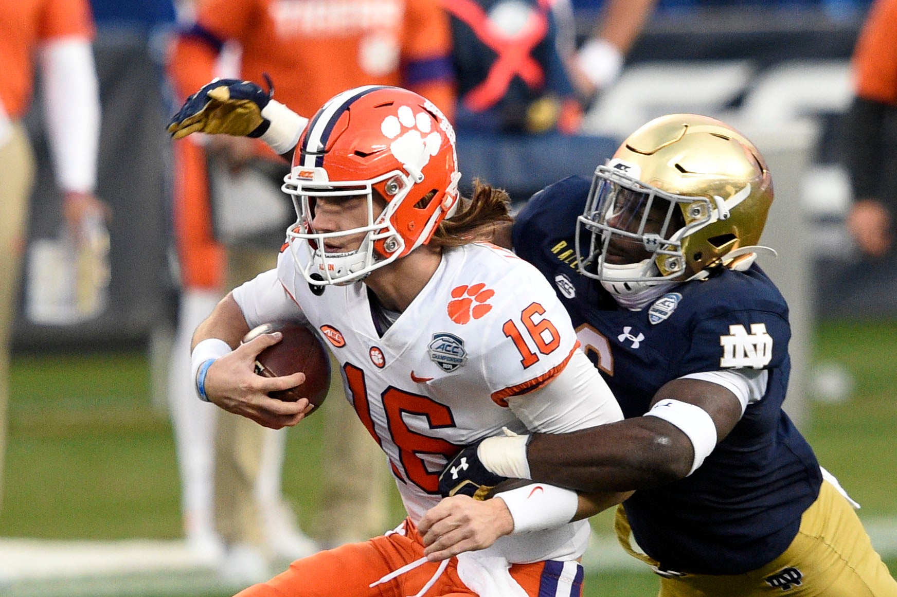 Dec 19, 2020; Charlotte, NC, USA; Clemson Tigers quarterback Trevor Lawrence (16) with the ball as Notre Dame Fighting Irish linebacker Jeremiah Owusu-Koramoah (6) defends in the second quarter at Bank of America Stadium. Mandatory Credit: Bob Donnan-Imagn Images