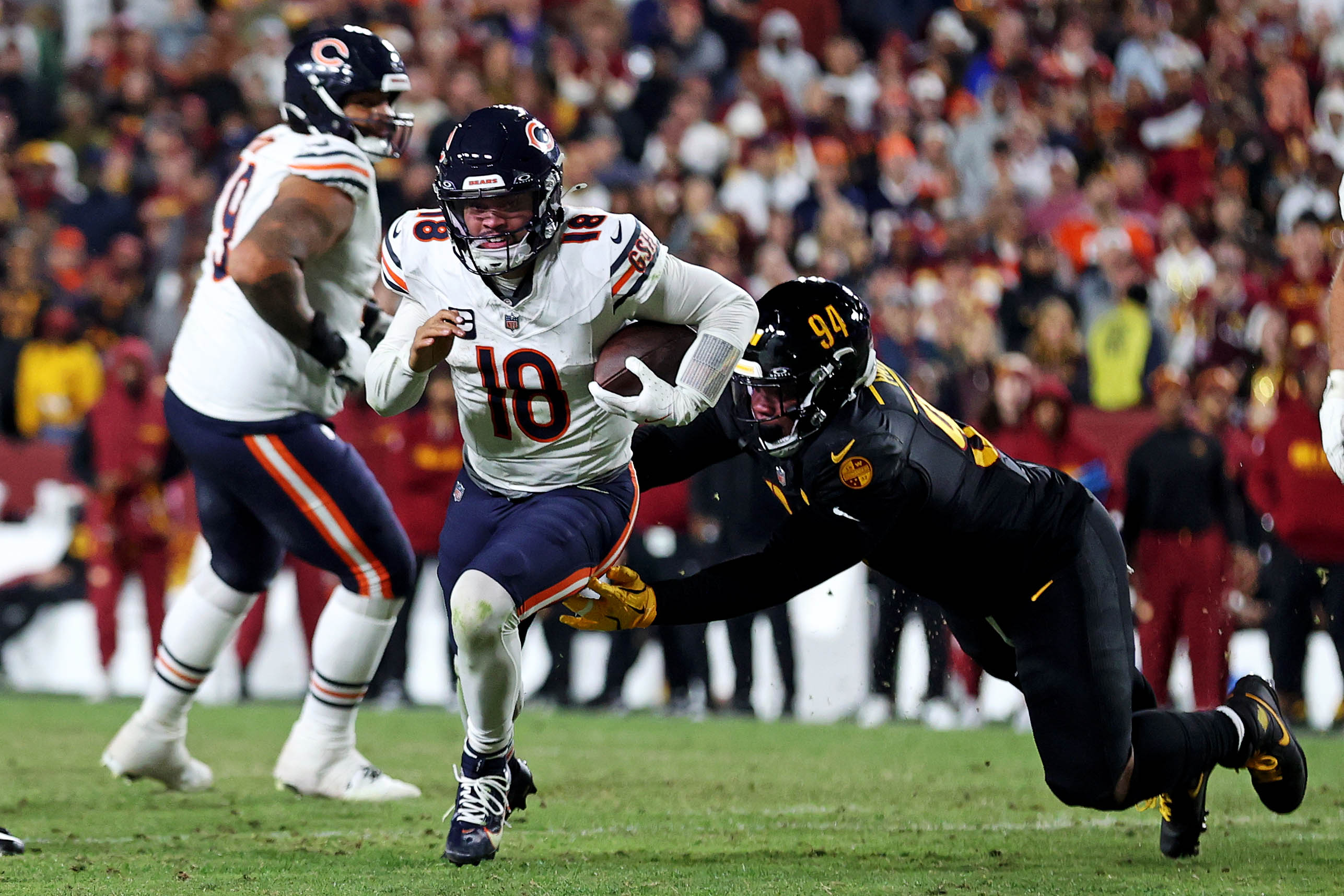 Oct 27, 2024; Landover, Maryland, USA; Chicago Bears quarterback Caleb Williams (18) runs the ball against Washington Commanders defensive tackle Daron Payne (94) during the fourth quarter at Commanders Field.