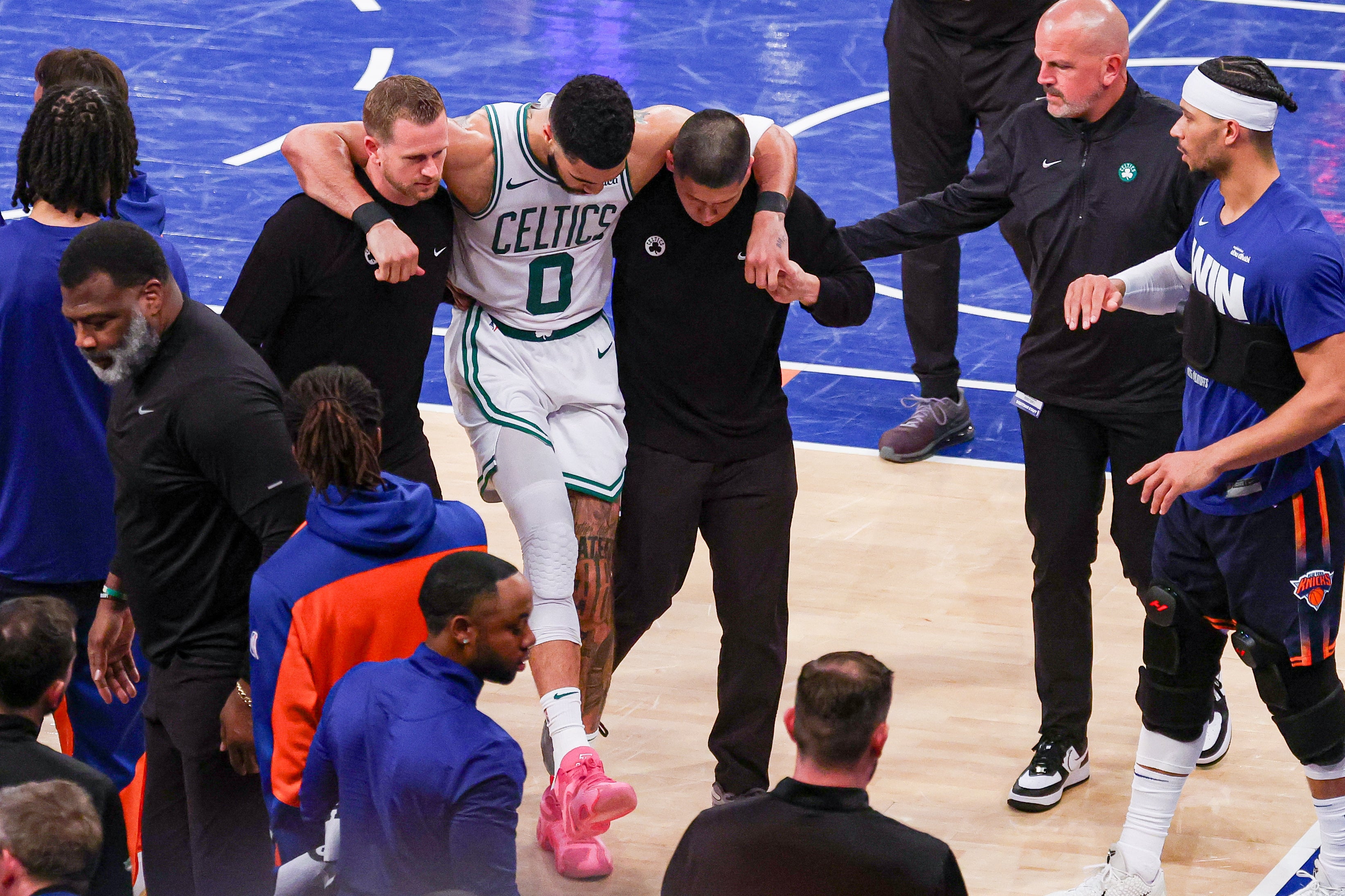 May 12, 2025; New York, New York, USA; Boston Celtics forward Jayson Tatum (0) is helped off the court by after an injury in the second half during game four of the second round for the 2025 NBA Playoffs against the New York Knicks at Madison Square Garden. Tatum would leave the game with an injury after this play