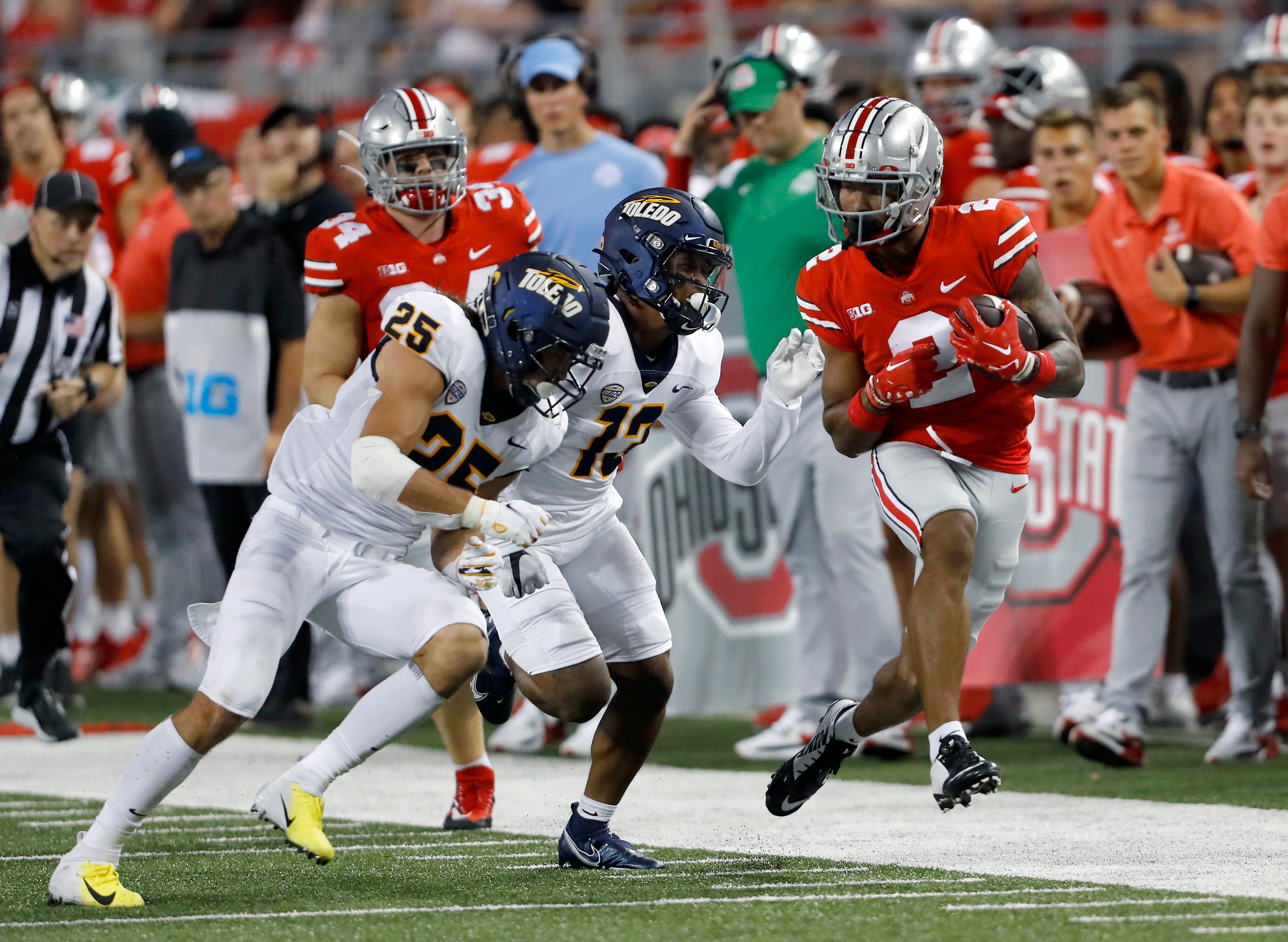 Sep 17, 2022; Columbus, Ohio, USA; Ohio State Buckeyes wide receiver Emeka Egbuka (2) runs the ball as Toledo Rockets cornerback Chris McDonald (13) and safety Maxen Hook (25) make the tackle during the second quarter at Ohio Stadium. Mandatory Credit: Joseph Maiorana-Imagn Images