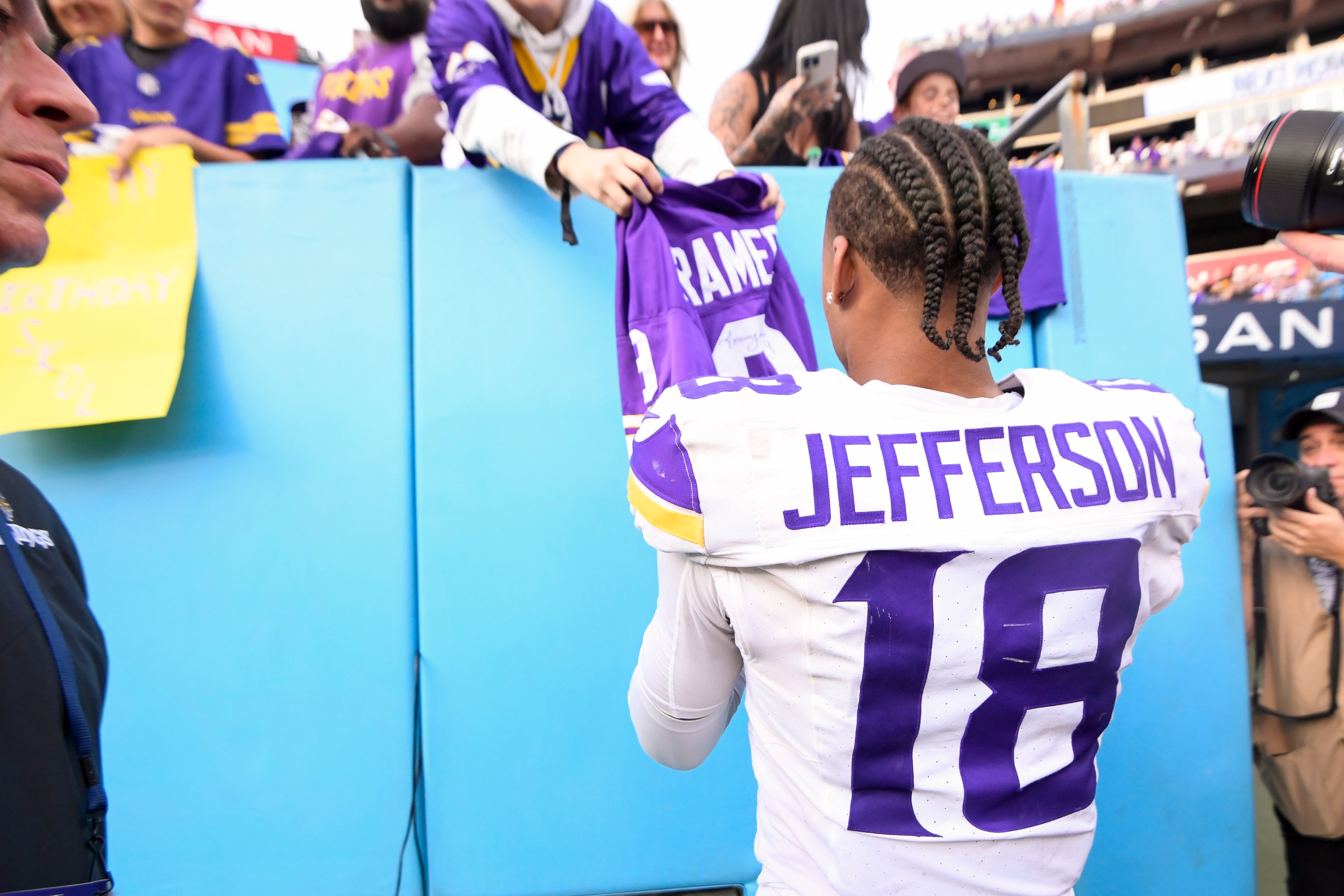Nov 17, 2024; Nashville, Tennessee, USA; Minnesota Vikings wide receiver Justin Jefferson (18) signs a fans jersey against the Tennessee Titans during the second half at Nissan Stadium.