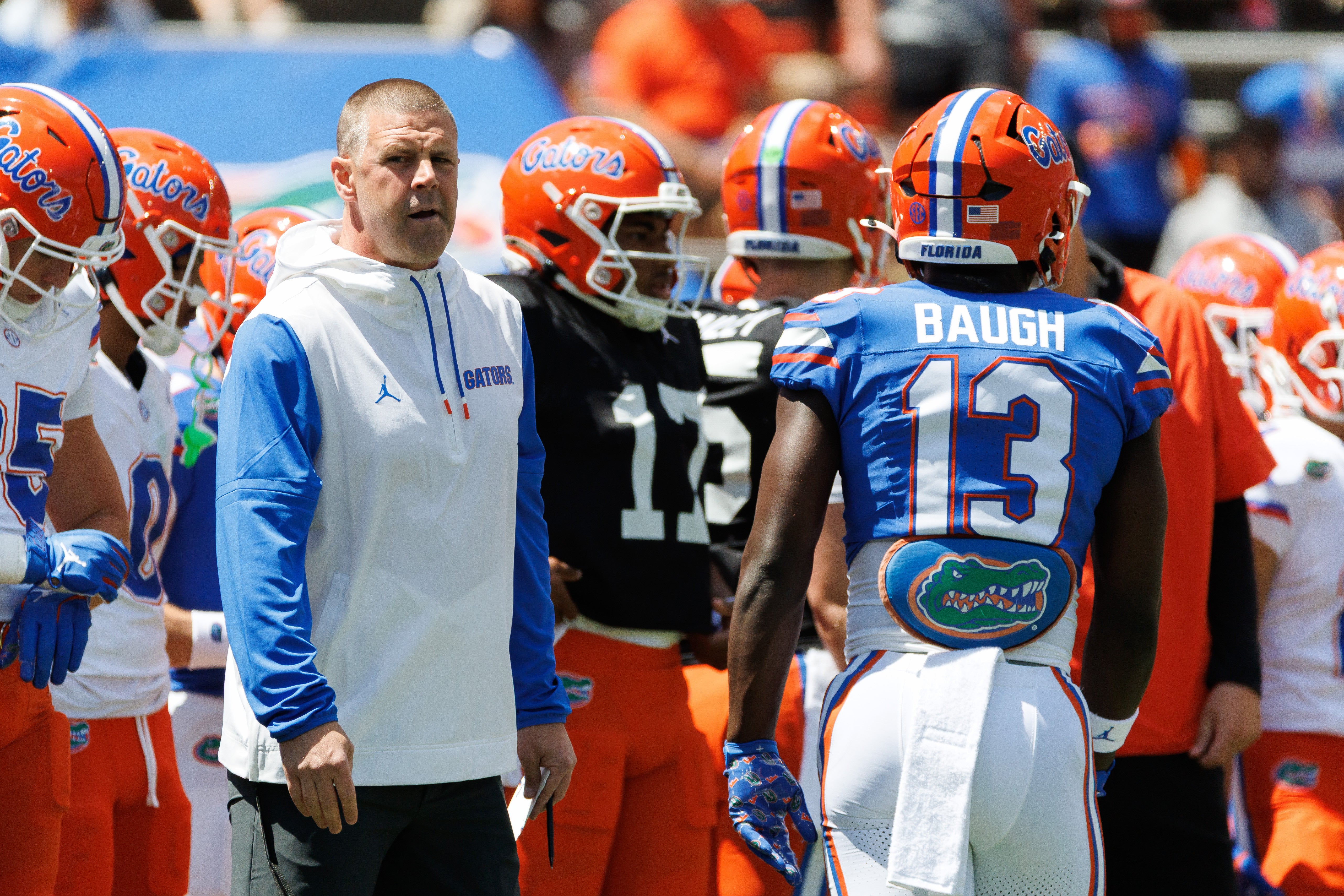 Apr 12, 2025; Gainesville, FL, USA; Florida Gators head coach Billy Napier looks on while Florida Gators running back Jadan Baugh (13) walks by before the game at Ben Hill Griffin Stadium.