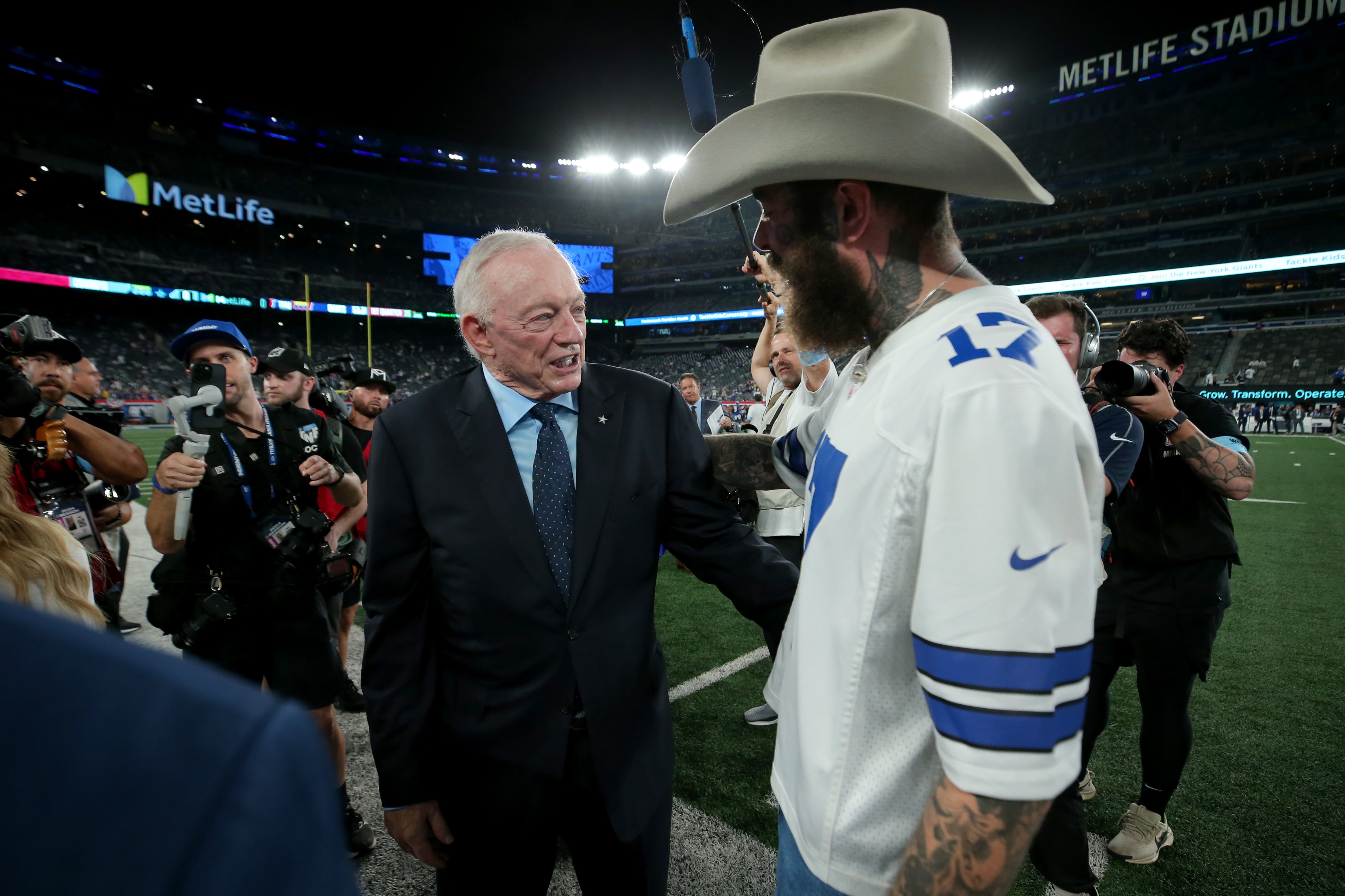 Sep 26, 2024; East Rutherford, New Jersey, USA; Dallas Cowboys owner Jerry Jones (left) greets American recording artist Post Malone on the field before a game against the New York Giants at MetLife Stadium.
