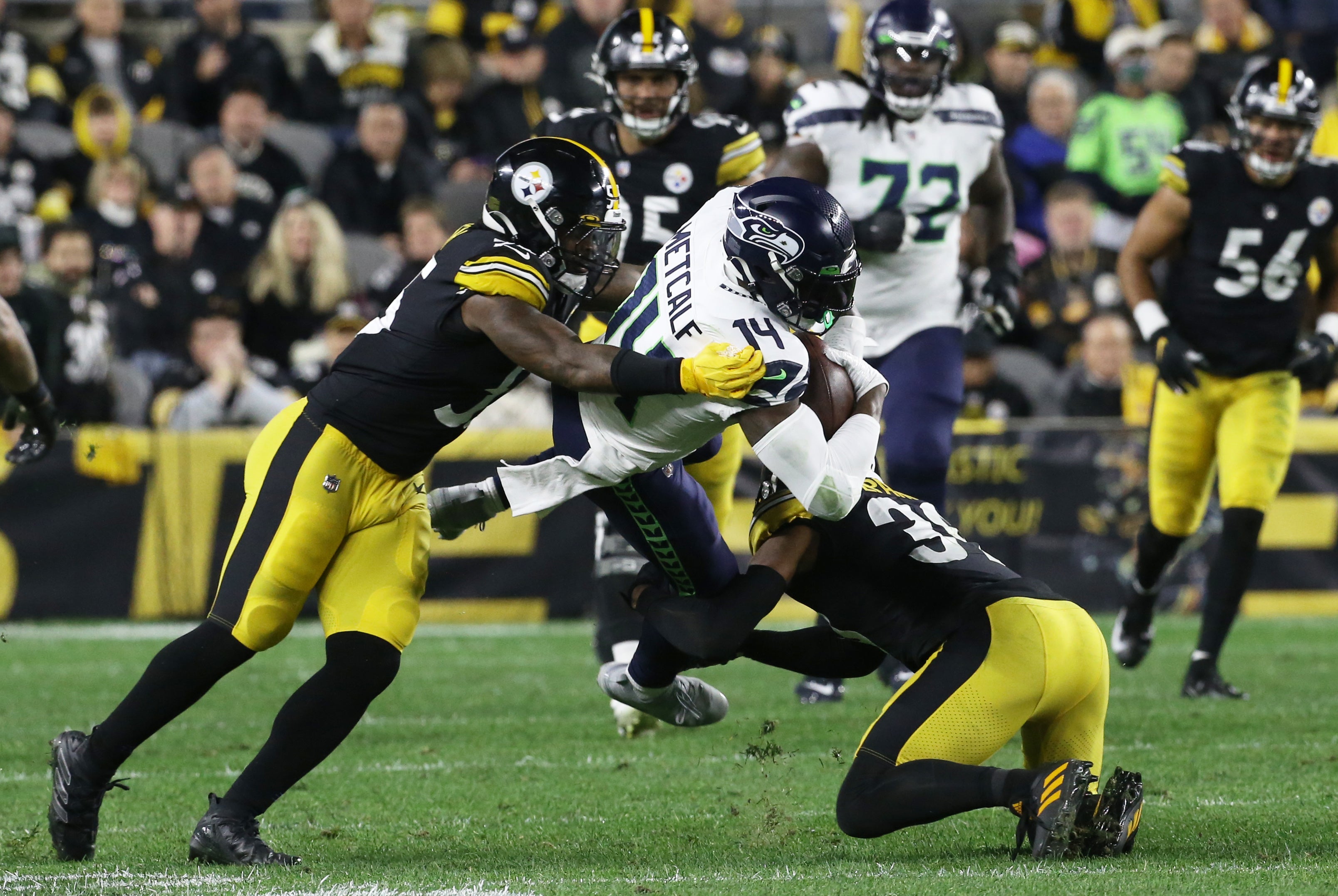 Oct 17, 2021; Pittsburgh, Pennsylvania, USA; Seattle Seahawks wide receiver DK Metcalf (14) is tackled after a catch by Pittsburgh Steelers inside linebacker Devin Bush (left) and free safety Minkah Fitzpatrick (39) during the second quarter at Heinz Field.
