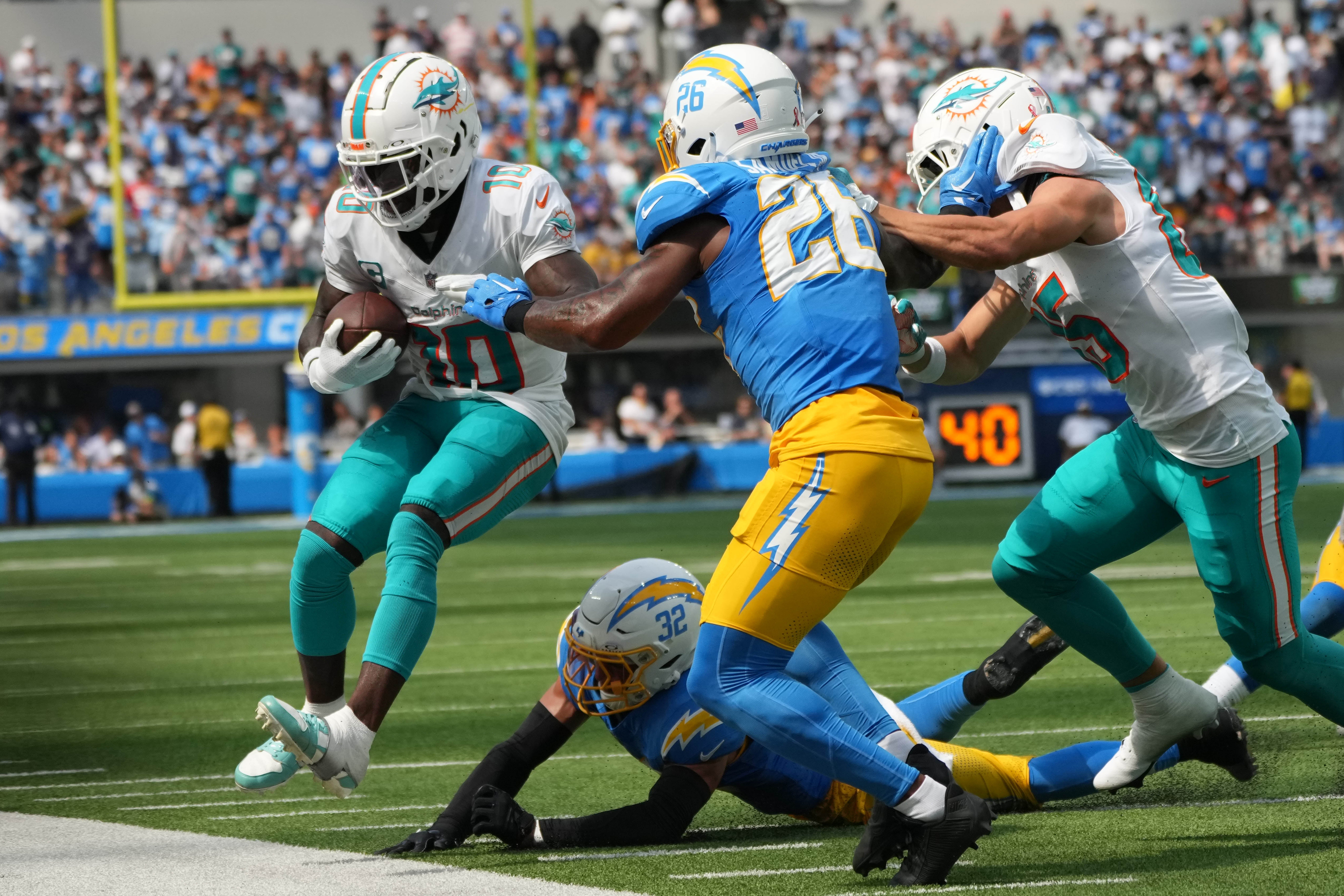Sep 10, 2023; Inglewood, California, USA; Miami Dolphins wide receiver Tyreek Hill (10) carries the ball against Los Angeles Chargers cornerback Asante Samuel Jr. (26) and safety Alohi Gilman (32) in the second half at SoFi Stadium.