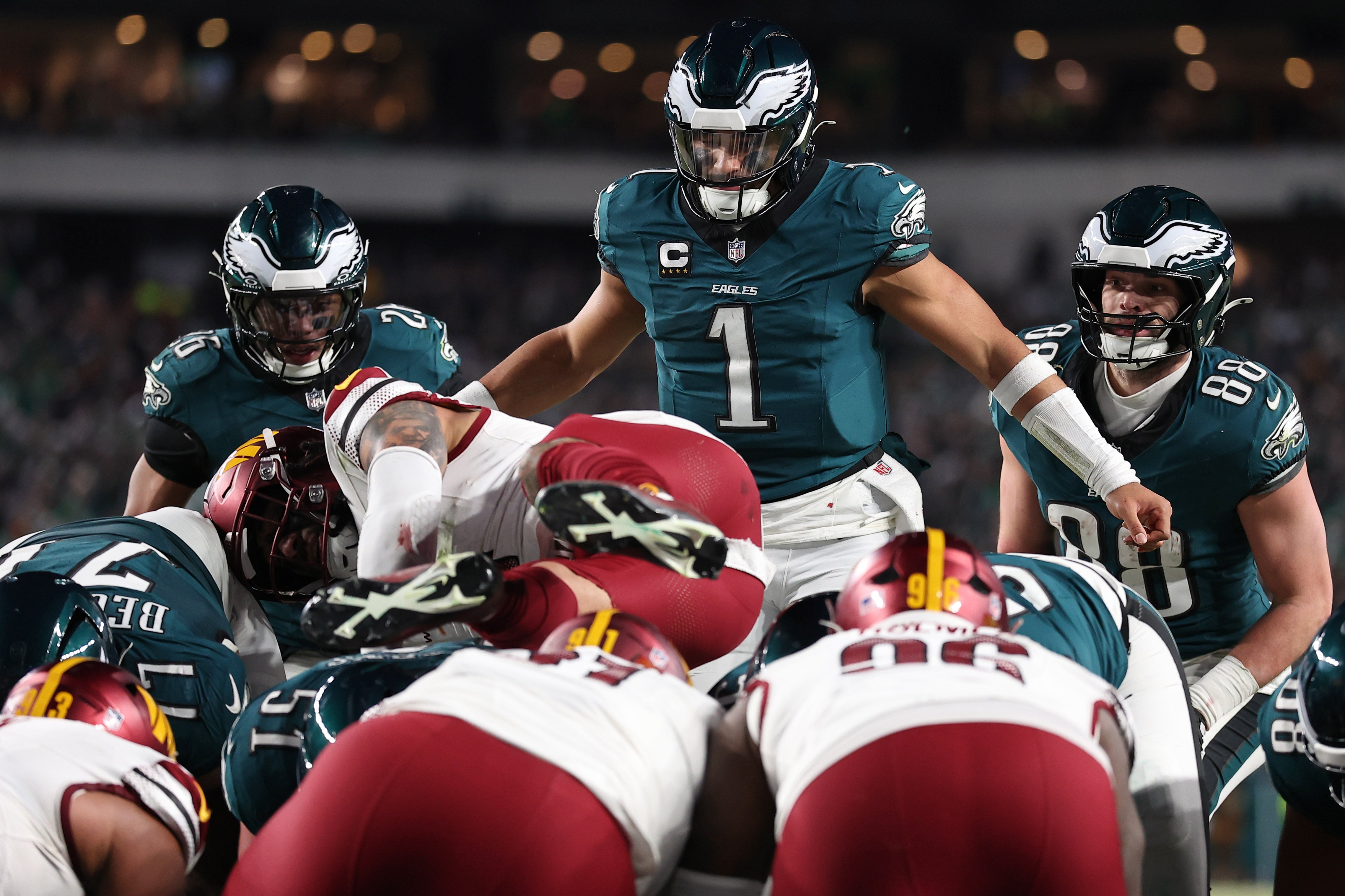 Philadelphia Eagles quarterback Jalen Hurts (1) reacts as Washington Commanders linebacker Frankie Luvu (4) leaps over linemen before a snap during the second half in the NFC Championship game.