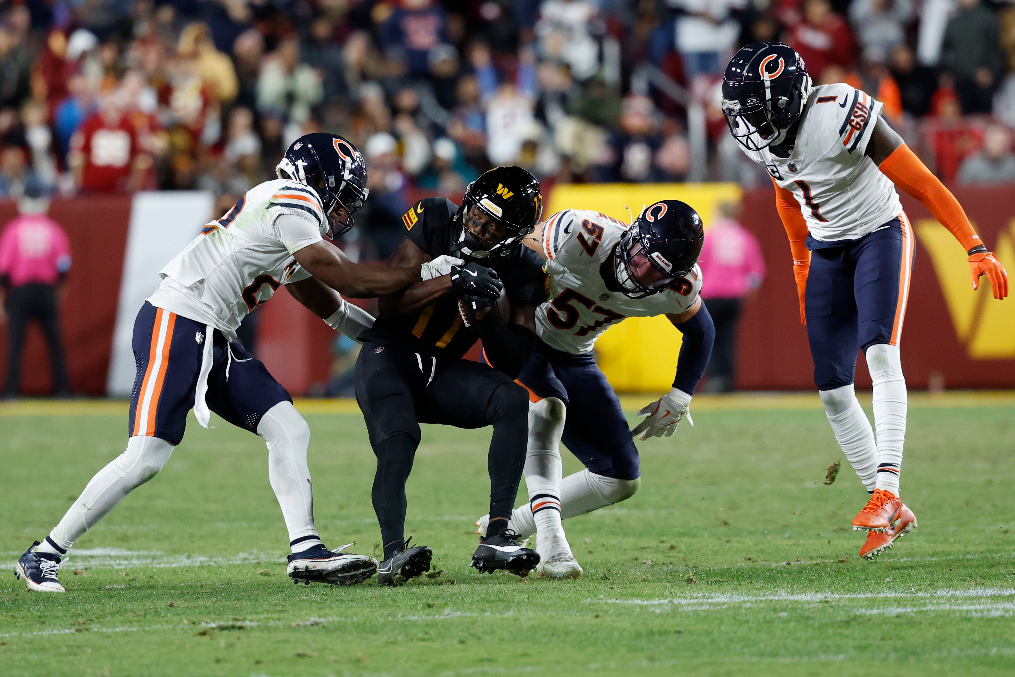 Washington Commanders wide receiver Terry McLaurin (17) catches a pass as Chicago Bears safety Elijah Hicks (22) and Bears linebacker Jack Sanborn (57) defend during the third quarter at Northwest Stadium.