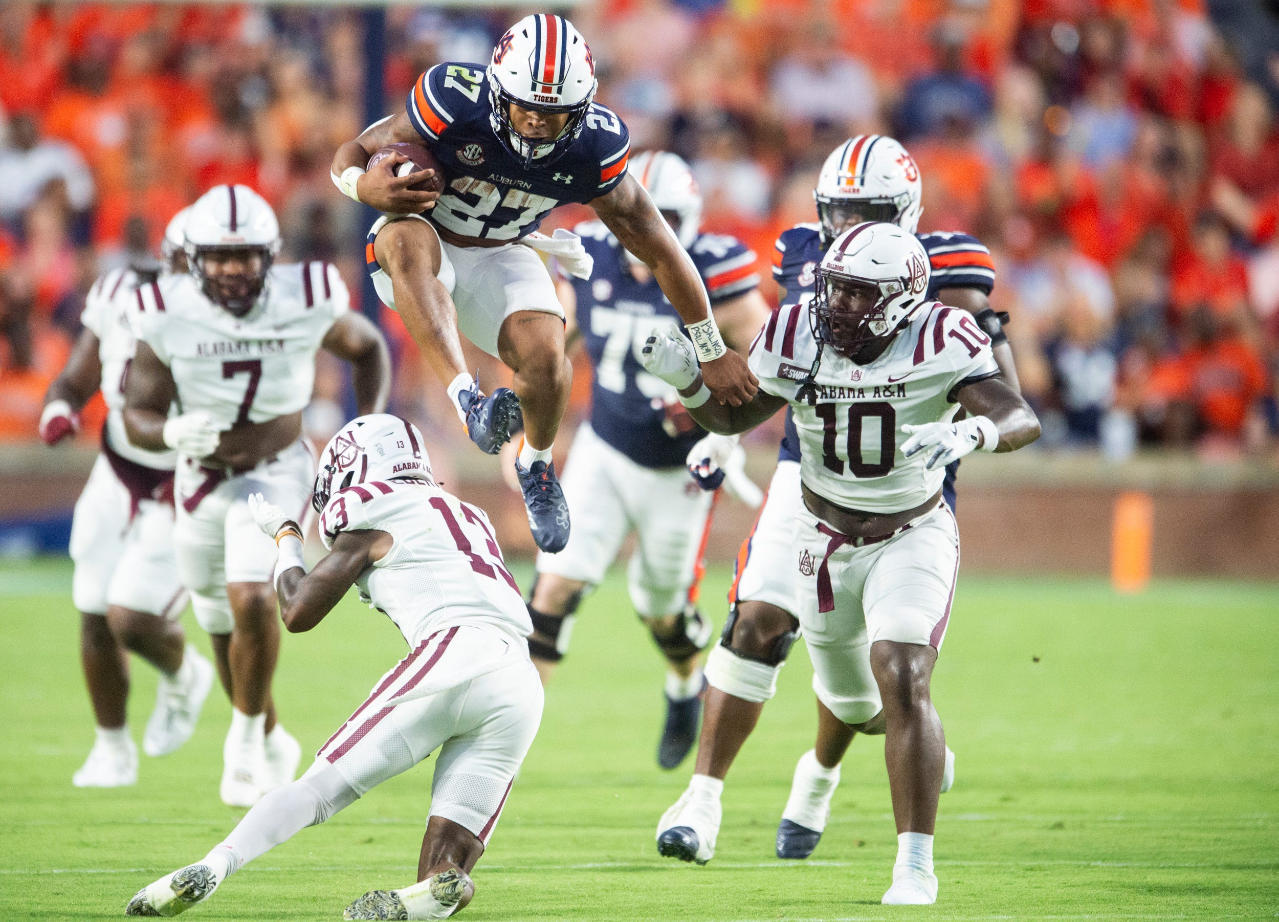 Auburn Tigers running back Jarquez Hunter (27) hurdles Alabama A&M Bulldogs defensive back Elijah Eberhardt (13) as Auburn Tigers takes on Alabama A&M Bulldogs at Jordan-Hare Stadium in Auburn, Ala., on Saturday, Aug. 31, 2024.