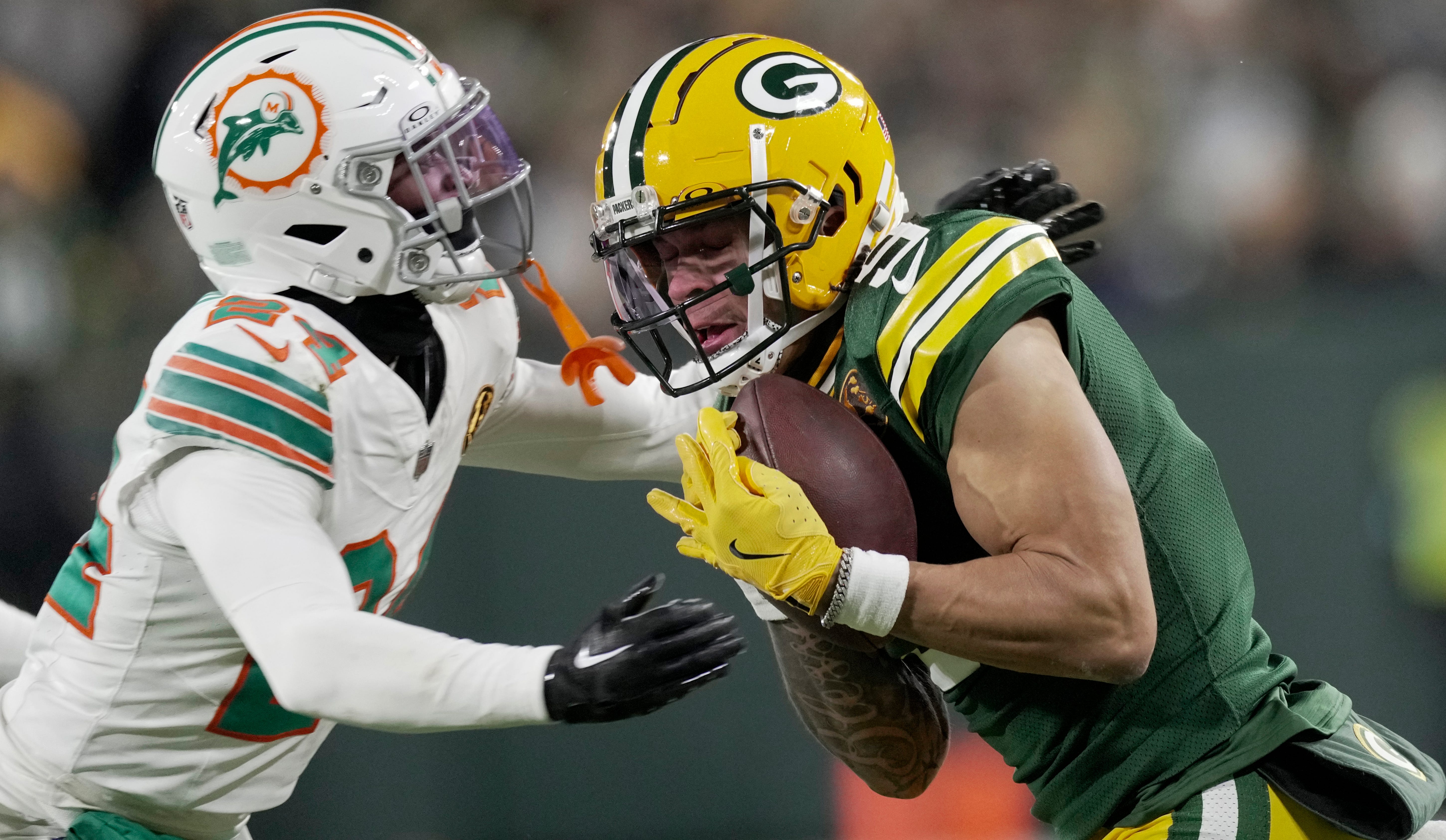 Green Bay Packers' Christian Watson (9) makes a 21-yard reception before being tackled by Miami Dolphins cornerback Cam Smith (24) during the second quarter of their game Thursday, November 28, 2024 at Lambeau Field in Green Bay, Wisconsin.